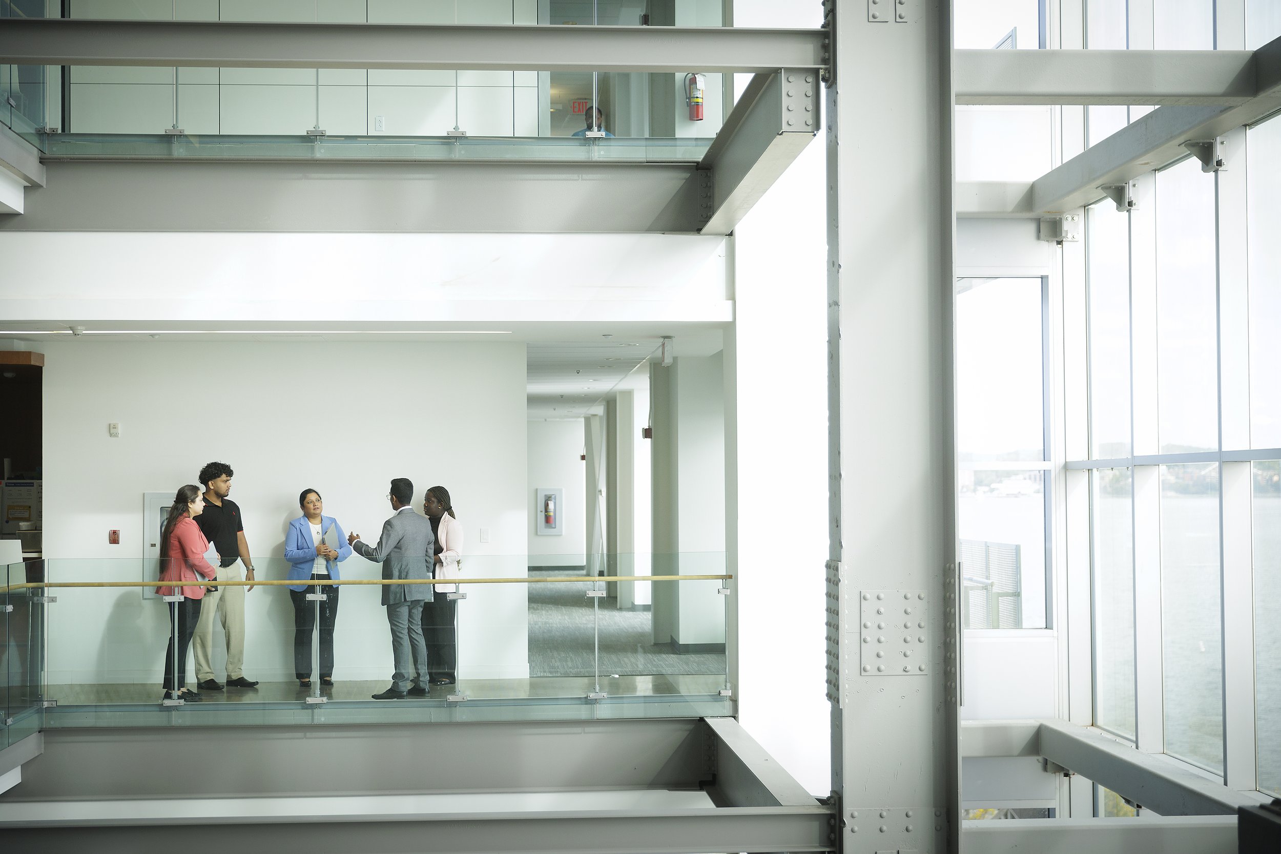 A photo from afar shows a group of people in a business office