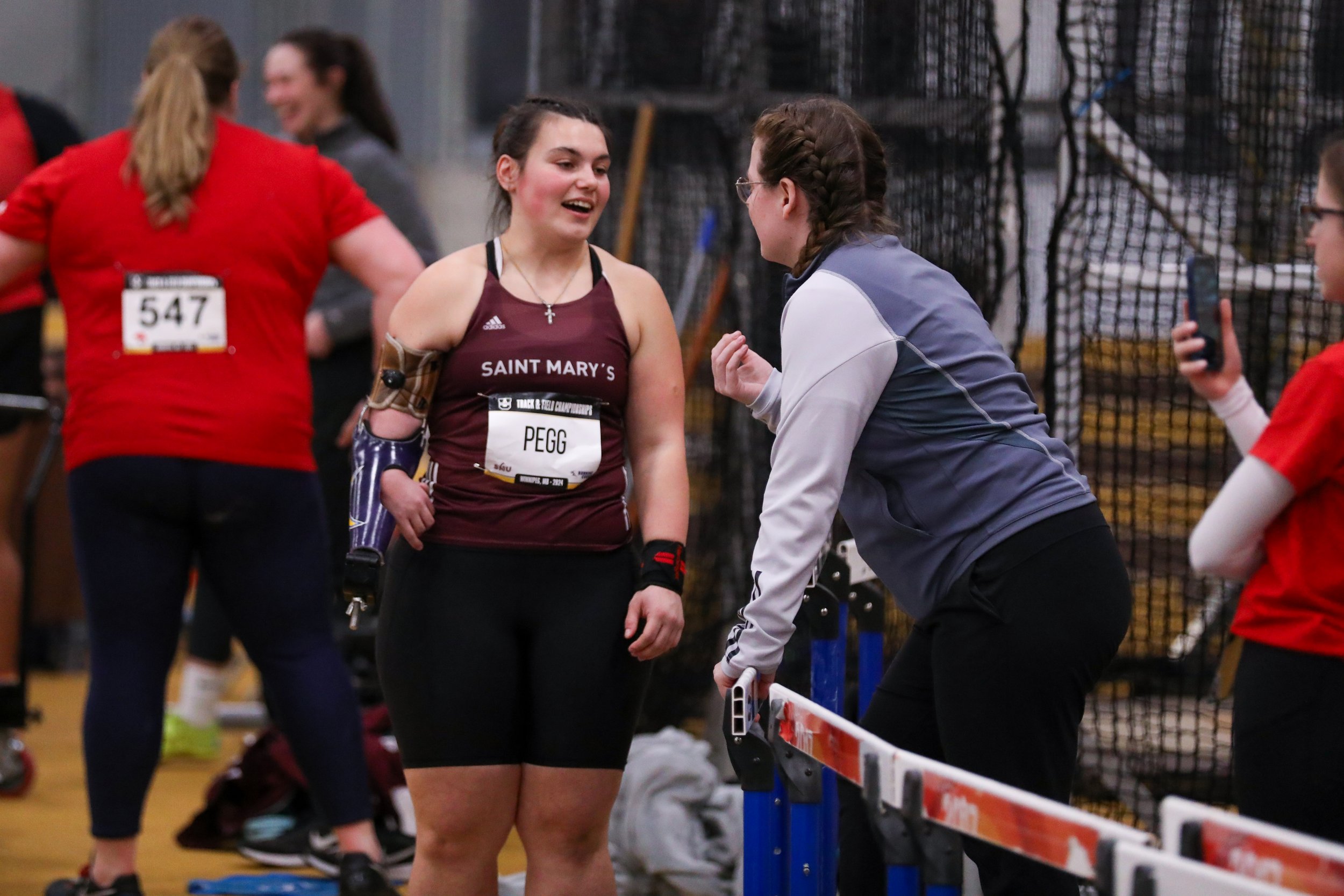 Katie talks to her coach during a track and field meet