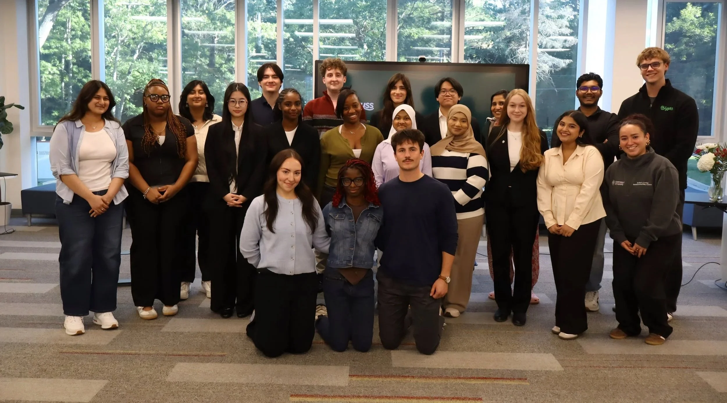 Students in a group shot at the front of a classroon.