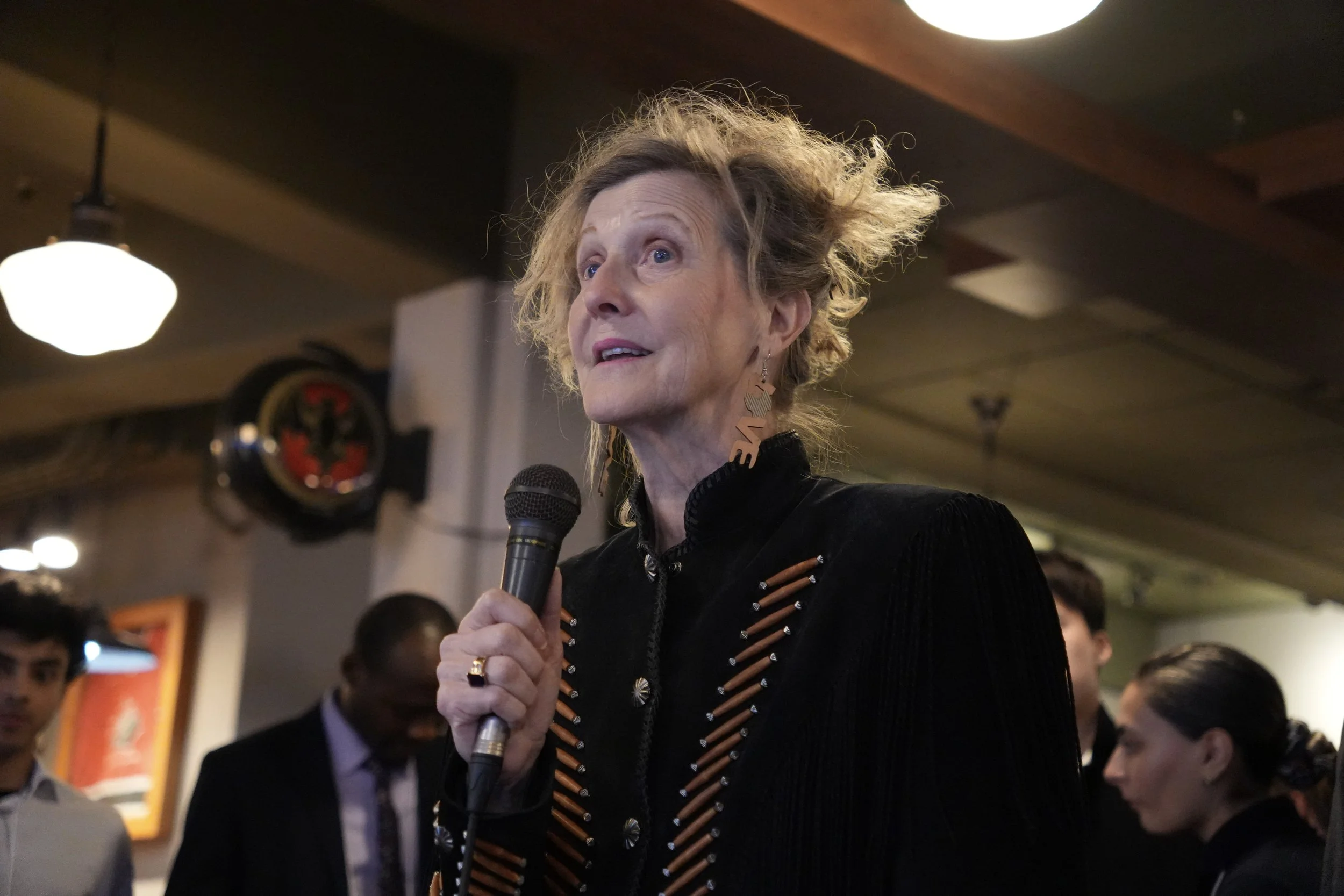 Ellen speaks in to a microphone at the event