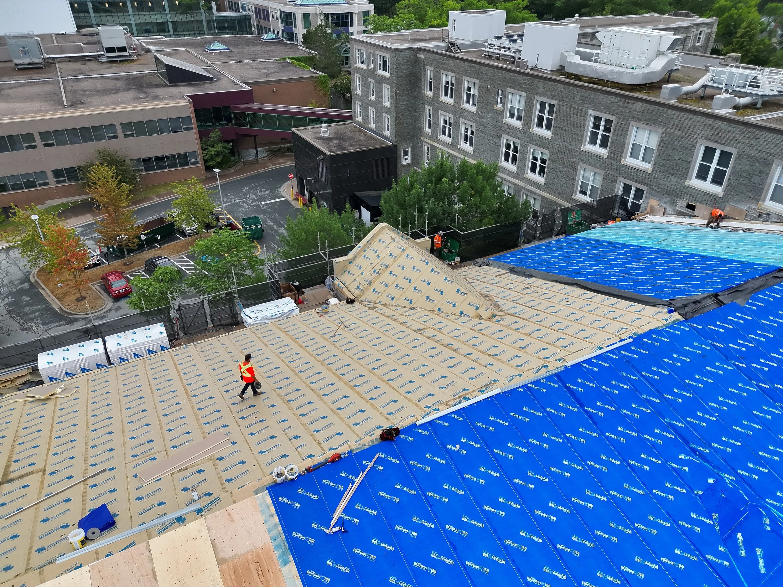 Construction material and a worker shown on the McNally East roof
