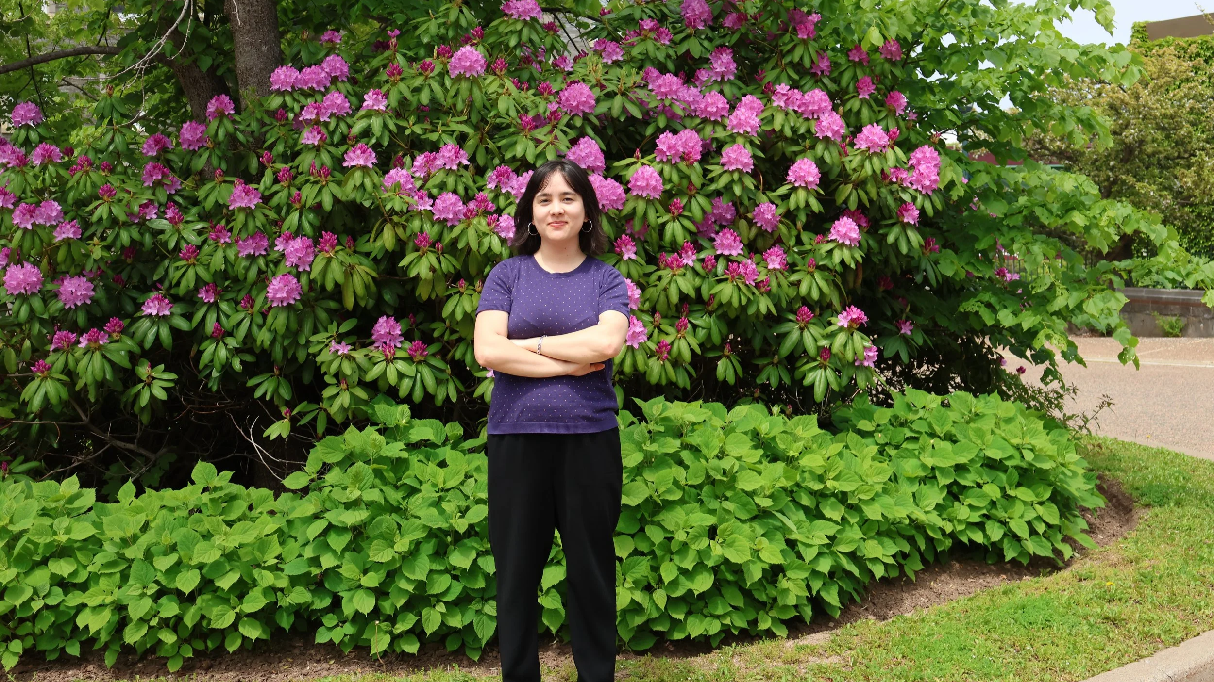Sarah Delorme stands outdoors in a garden