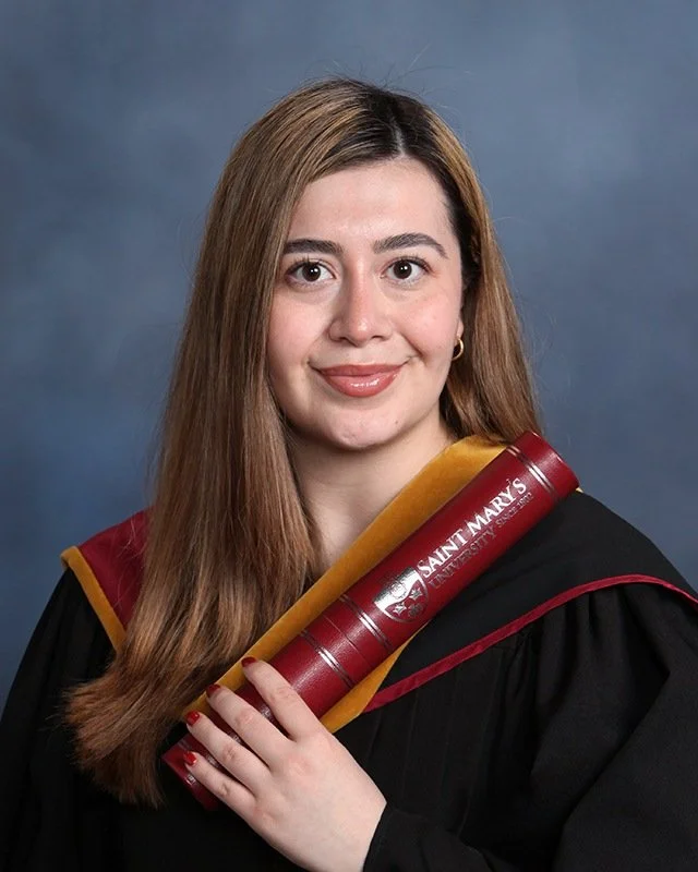 Melissa in a graduation gown holding a parchment
