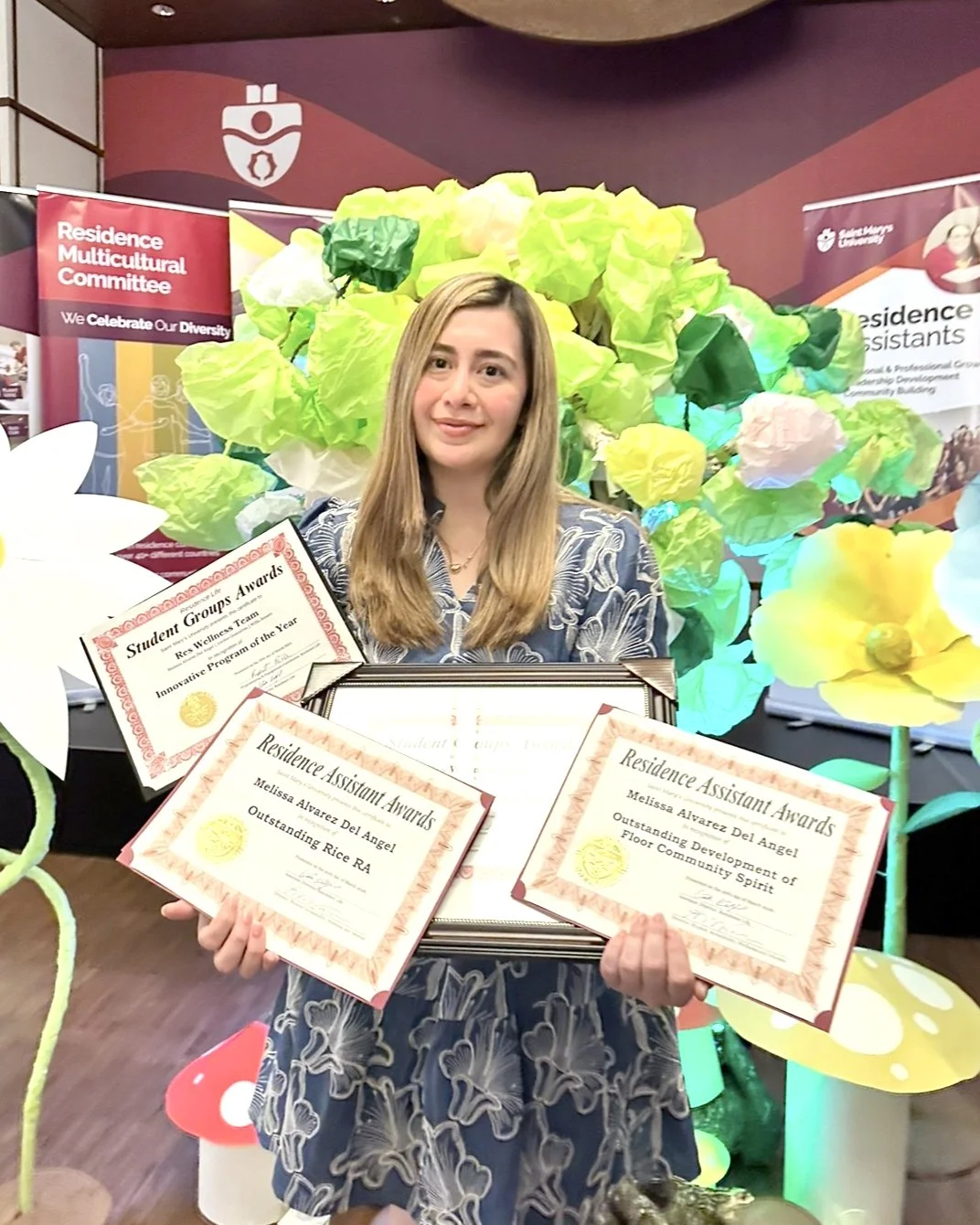 Melissa holds several award parchments