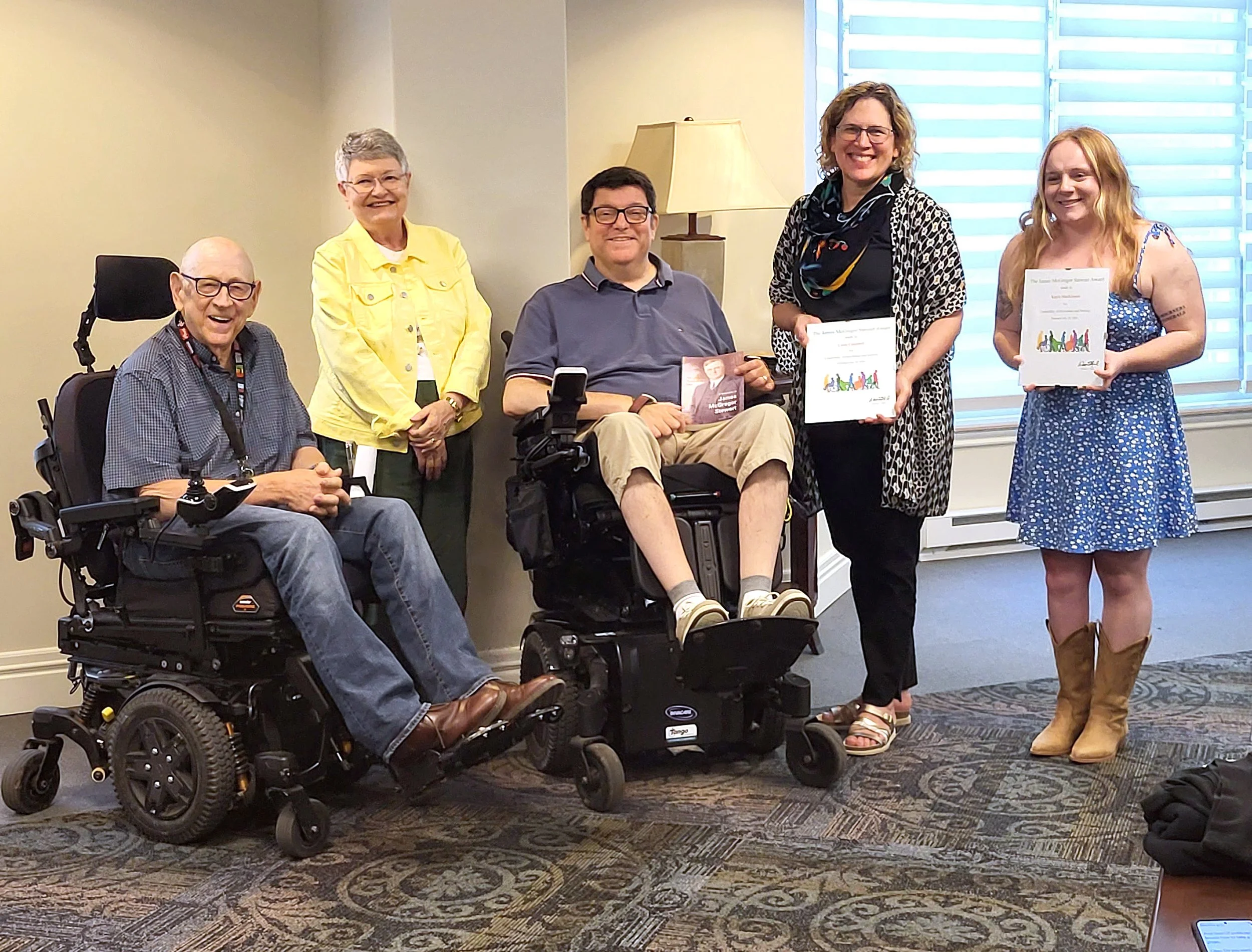 The group of five post together, Linda and Kayla hold their awards