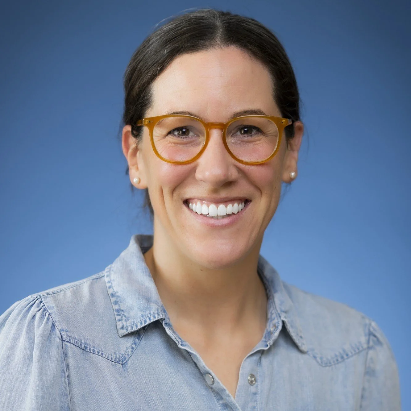 Stephanie is a white woman with brown hair and glasses