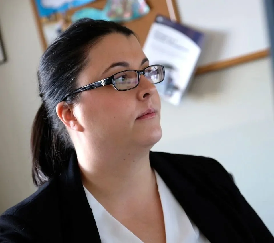 Amber is a white woman with brown hair and glasses