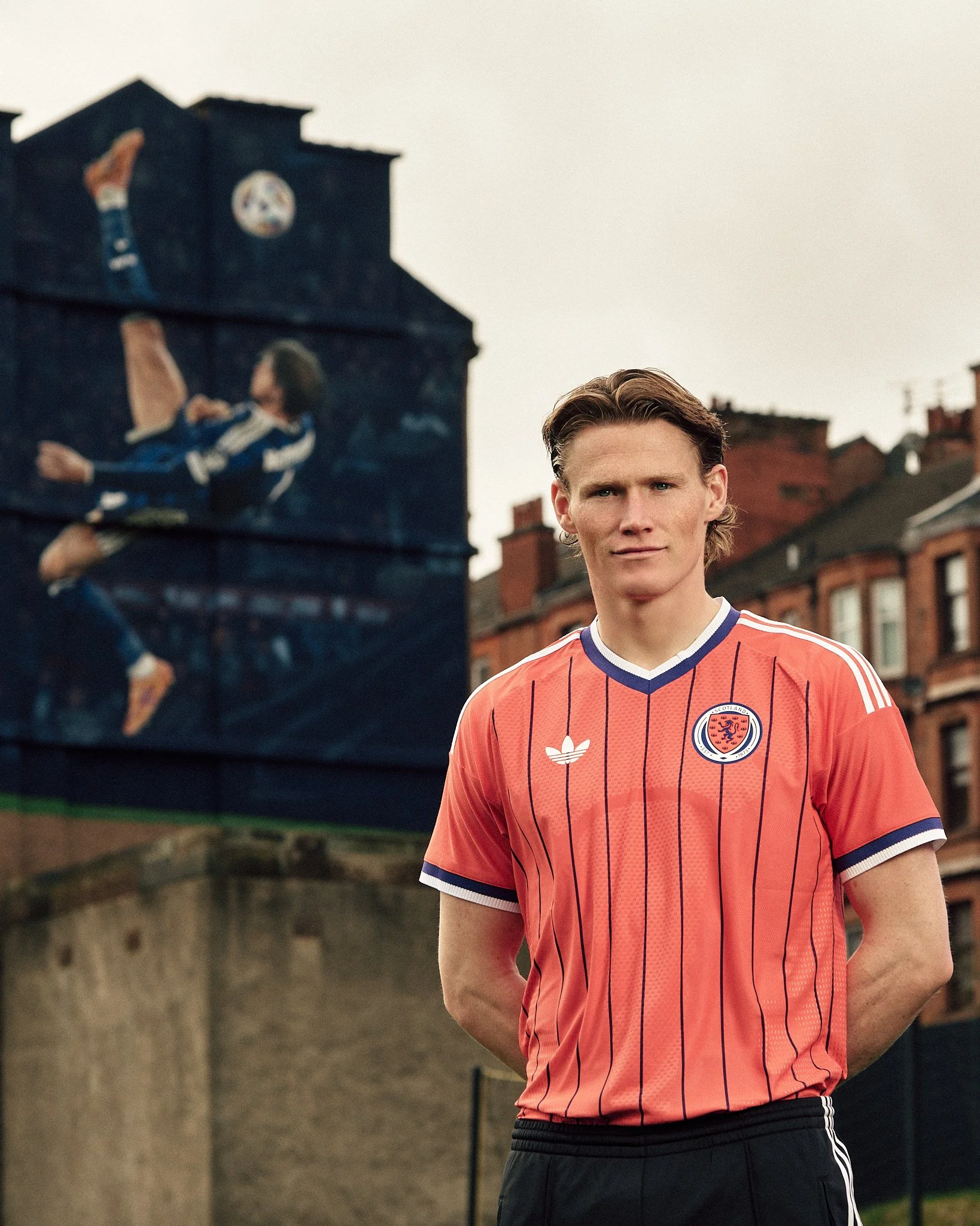 Scott McTominay standing outside Hampden Park wearing the new Scotland World Cup kit.
