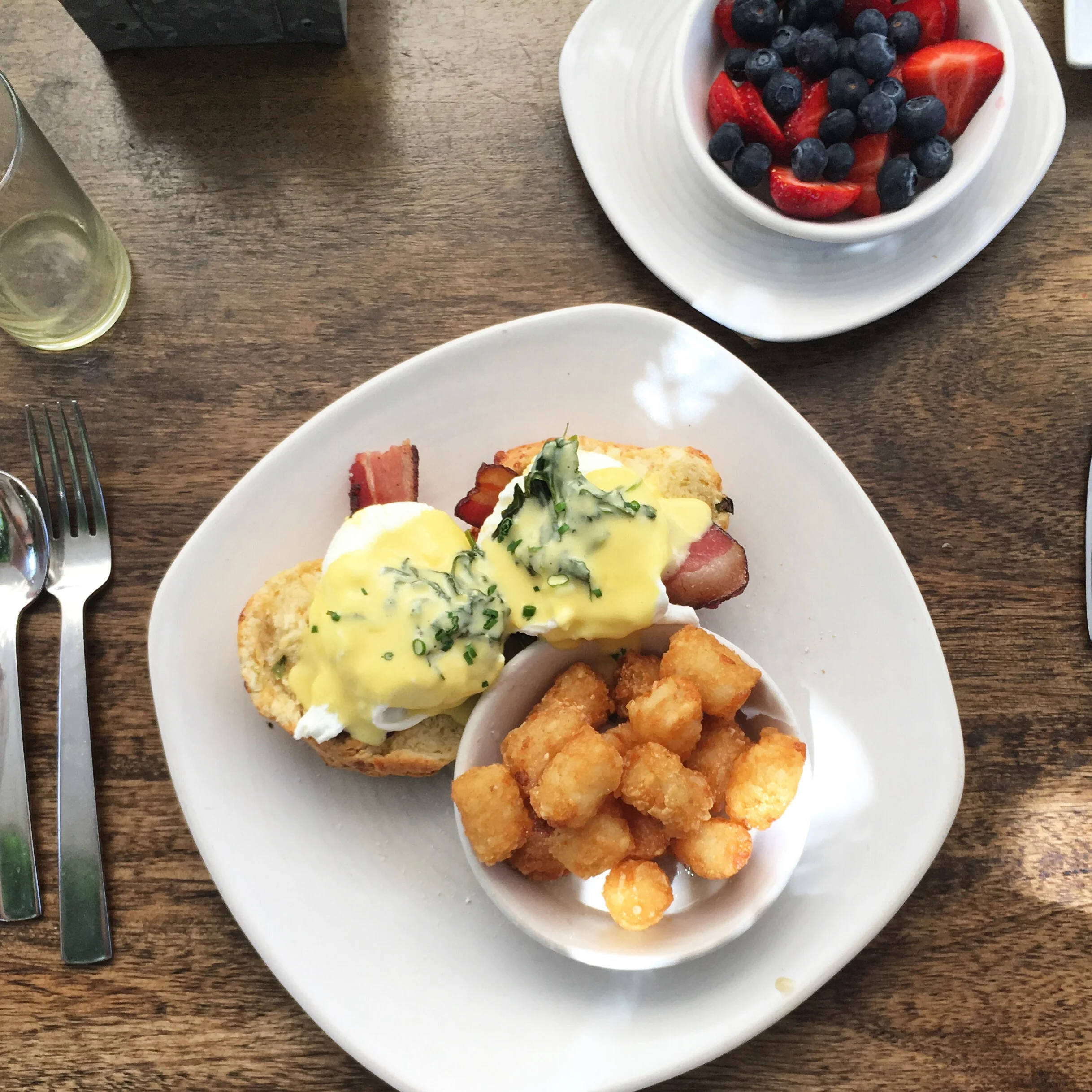 Cheekys Eggs Benedict with herbed hollandaise on a homemade scone, complimented by jalapeño tater tots