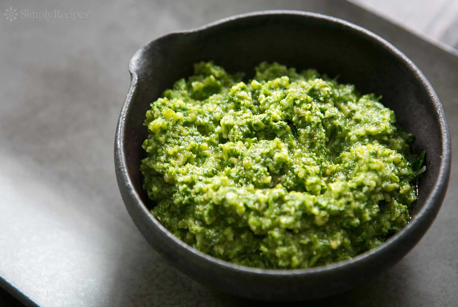 Easy and Durable Basil-Walnut Pesto Place one cup of walnuts, 1 minced garlic clove and 1/2 teaspoon of sea salt in your food processor and grind till nuts are grainy. Add three cups of fresh basil leaves (till it fills your container), drizzle 1/4 to 1/2 cup of finest quality olive oil over the top, then grind till you have a serviceable, coarse paste. (I often make extra to store in zip-lock plastic bags that I flatten into "bricks" and stack in my freezer. Keeps for months without losing flavor.)