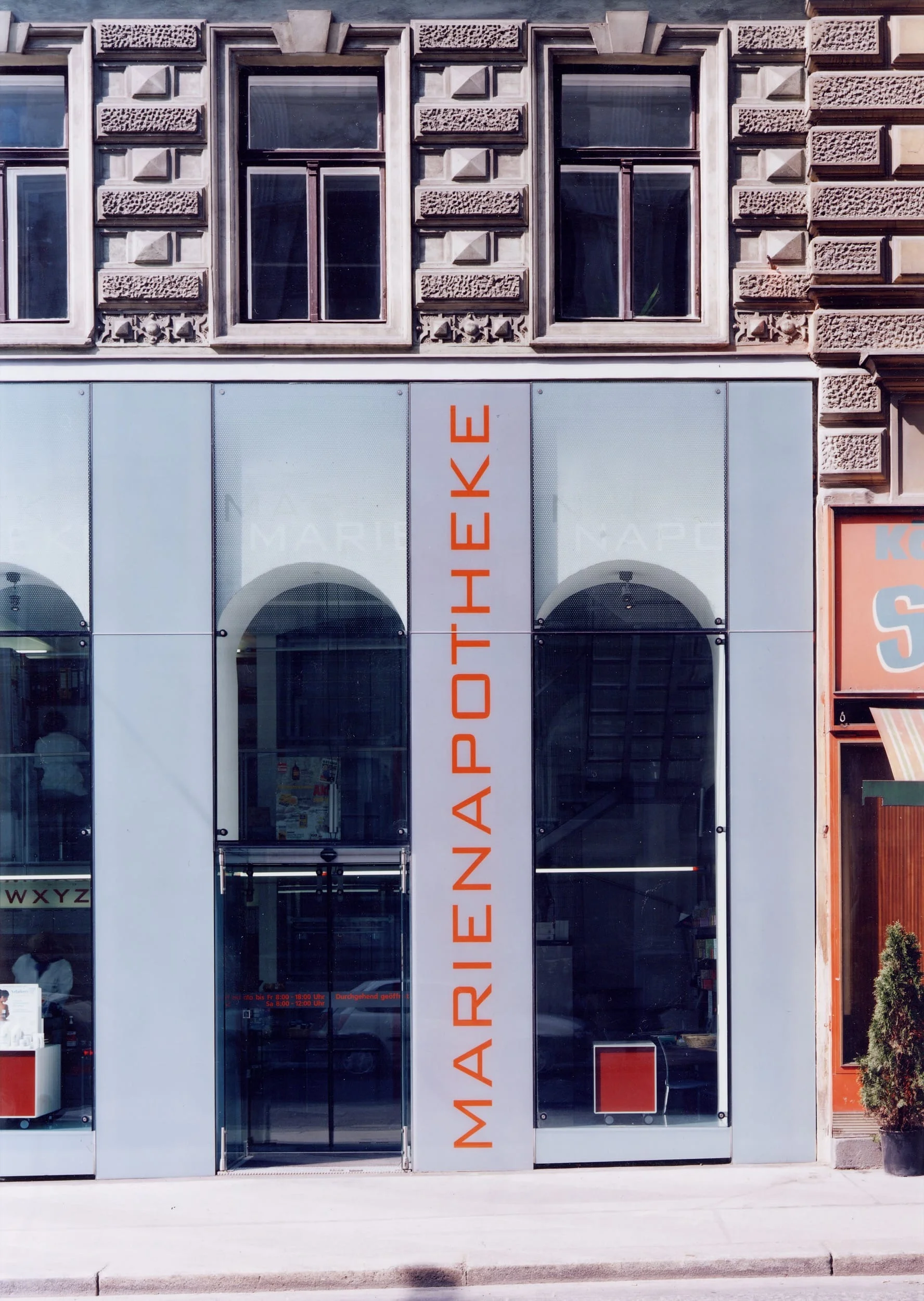 ...bündig in der fassade liegende, punktgehaltene nachtabschlußtüren und dahinterliegende, automatische nurglasschiebetüren komplettieren, die kaum durch massive konstruktive teile beeinträchtigte glasfassade... ...im inneren des verkaufsraumes stehen die begehbaren schaufensterböden aus emailliertem isolierglas und die isolierglasdeckel, zwischen nachtabschluß und schiebetüre, in direkter verbindung mit der fassade.