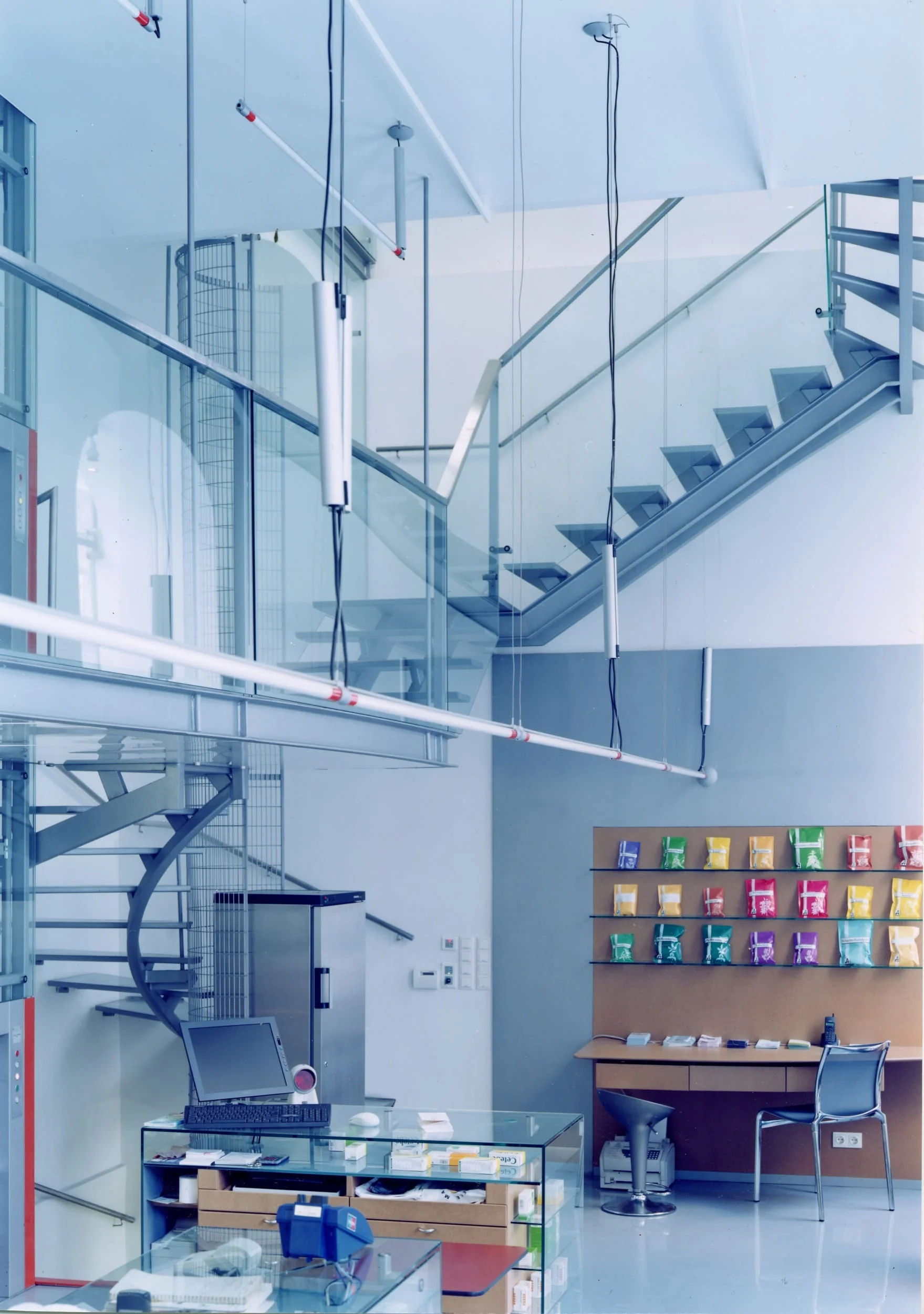  ...durchsicht und klarheit auch in der vertikalen - eine transparente stiege aus stahl und glas mit einer galerie auf halber höhe... ... die offenheit des verkaufsraumes wird im obergeschoss fortgesetzt glasflächen und grossflächige schiebetüren las