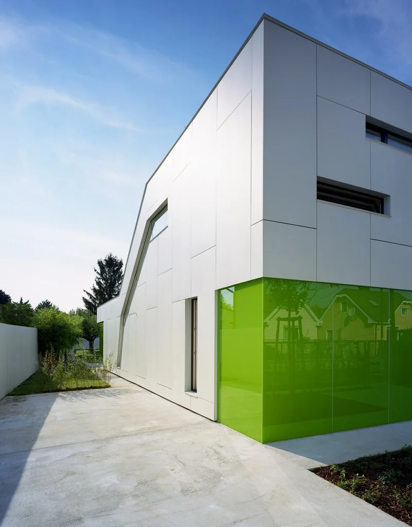  im aussenraum wird die elfenbeinfärbige farbe der fassade durch die verwendung von gleichfärbigem wegebeton für die befestigten flächen fortgesetzt. 