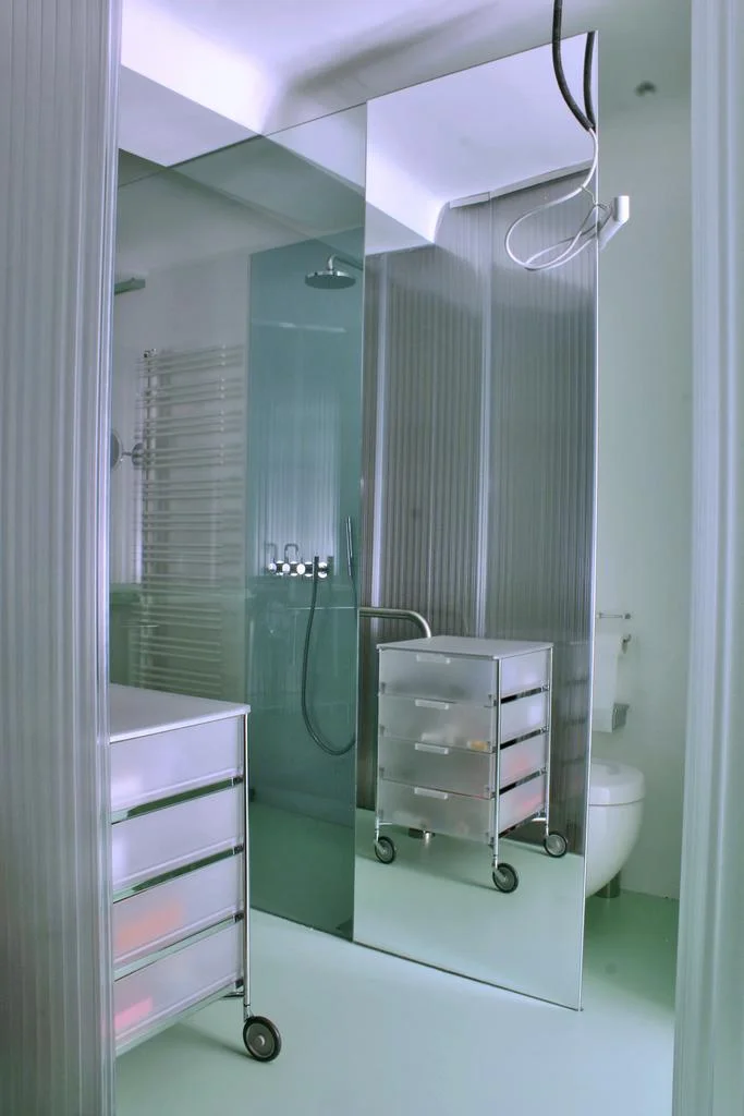 das bad als eigenständiges implantat im vorraum und zimmer, drei funktionen (bad, wc und sauna) auf kleinem raum stark komprimiert...