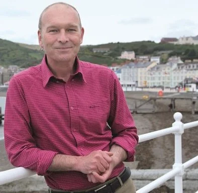 Mike Parker’s writing always begins from a sense of place, Wales in particular. That has sparked various narrative non-fiction books, including Map Addict, The Wild Rover and Real Powys , TV and radio programmes and some one-man stand-up shows. Politics is always there too. after failing to become the Plaid Cymru MP for Ceredigion in 2015, wrote The Greasy Poll about the "drumbeat rise of neo-fascism" that I'd found on the campaign trail. That was before Brexit, before Trump: the signs were all there. His new book, On the Red Hill , to be published in June 2019 by William Heinemann, is a celebration of the queer rural, love, acceptance, finding home and the redemptive power of nature, and all in the hills around Machynlleth.