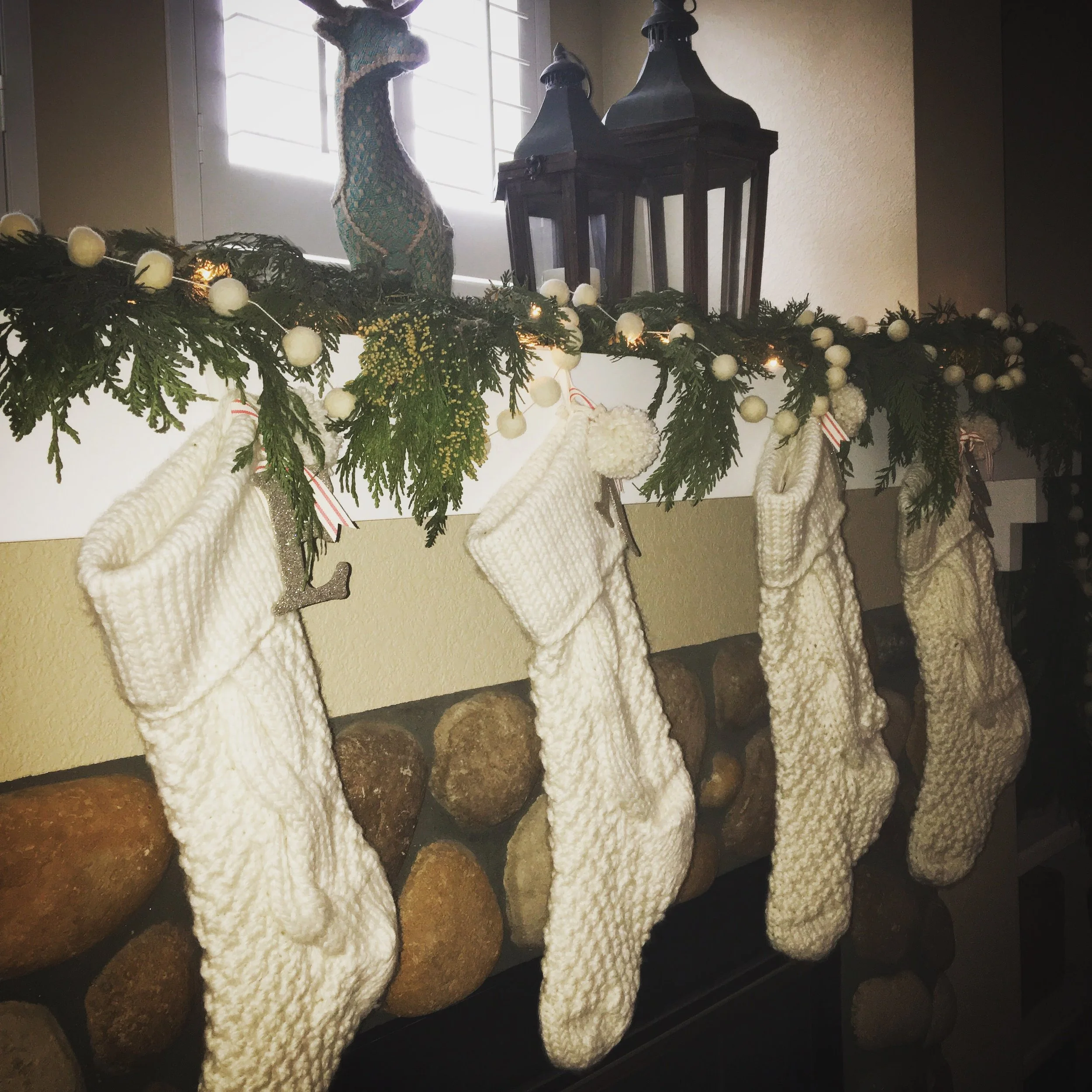 I LOVE the cream stockings I got on sale at Pottery Barn last year! I used fresh cedar garland {that I got at Home Depot} with cream felt ball garland, and white lights to make the mantel simple but festive.