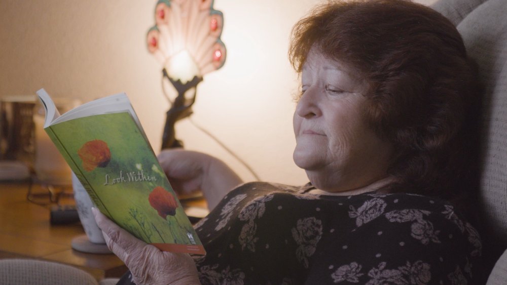 Nadean Cain enjoying a book in her home at Lone Oak Senior Housing in Penn Valley