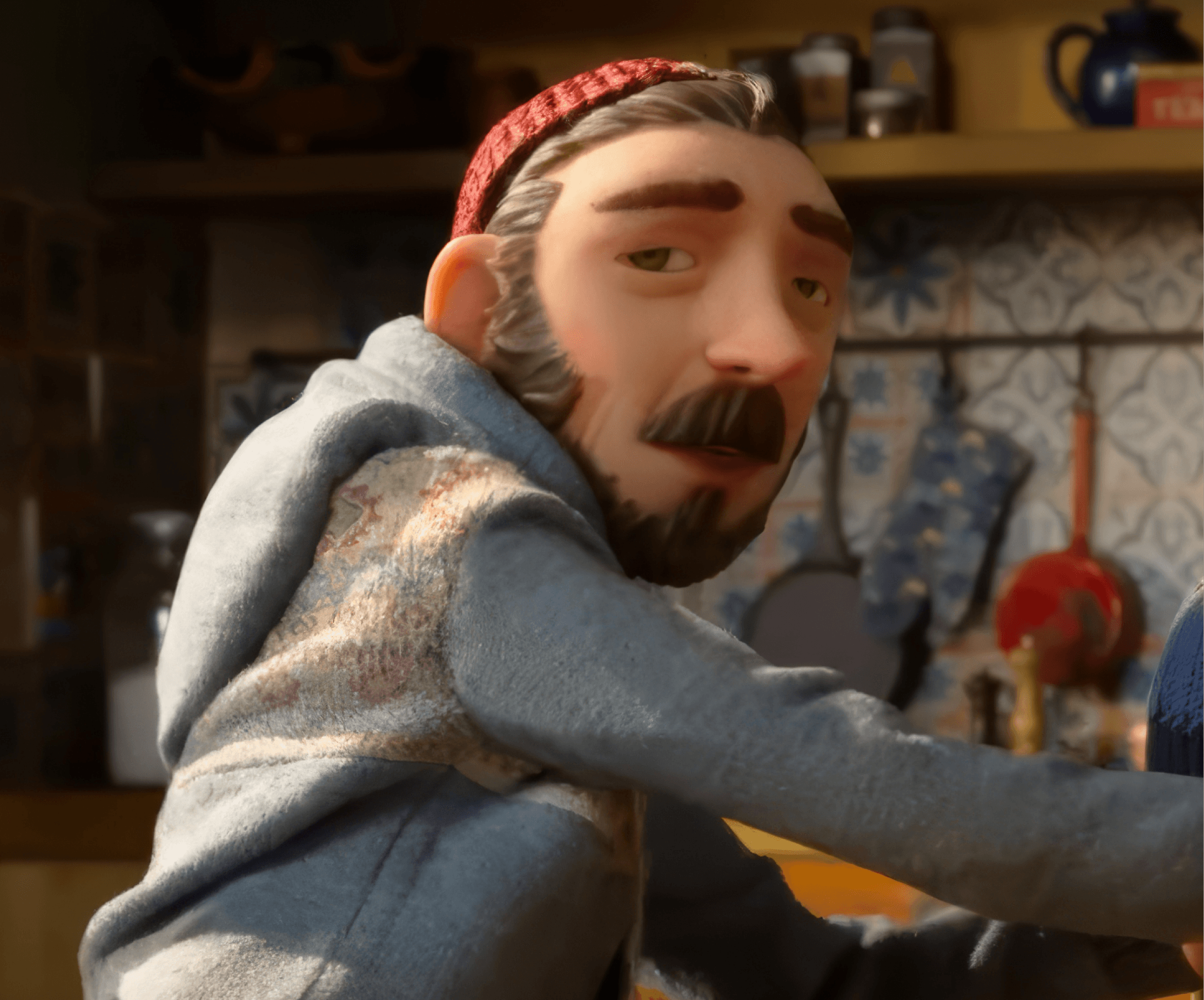 Mr. McKeel, wearing a red beanie, reaches across the kitchen table to adjust a knit cap on a young child, in a scene from LAIKA's stop-motion feature Wildwood.