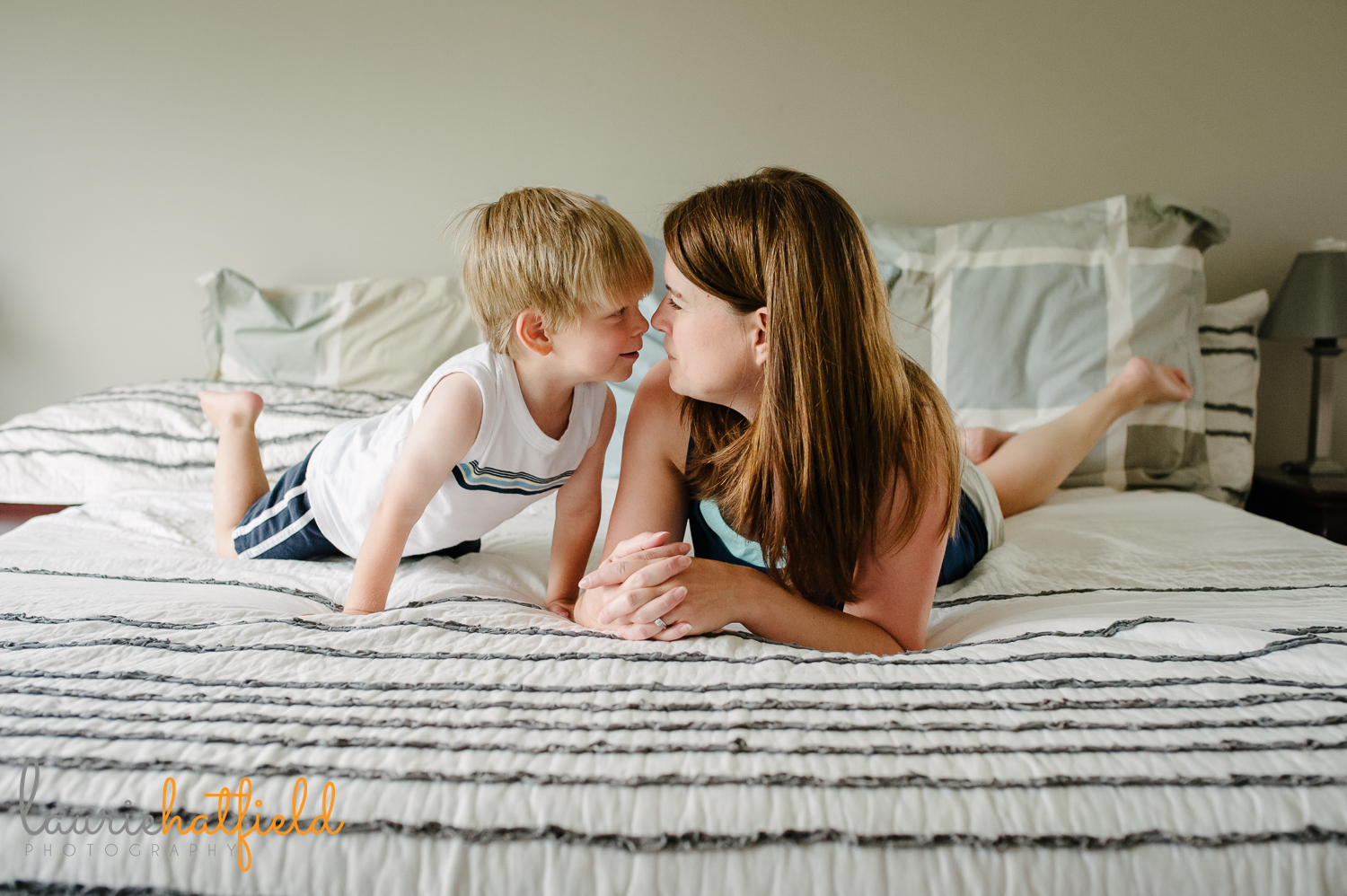 mom and son touching noses on bed | Huntsville family photographer