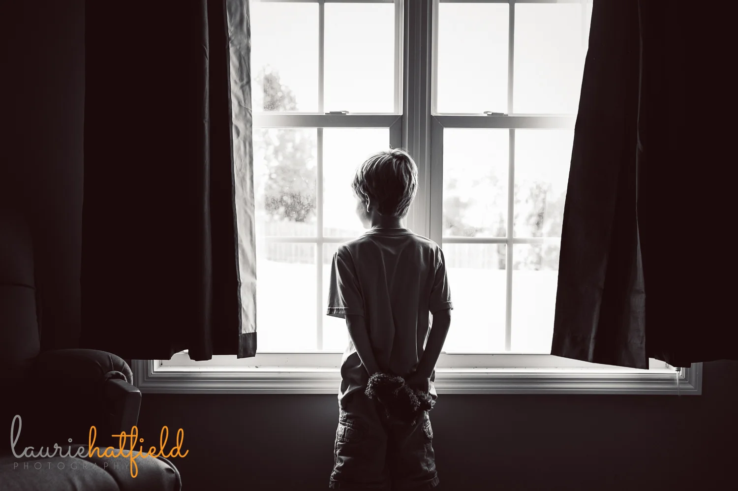little boy standing at window holding stuffed animal | Huntsville child photographer