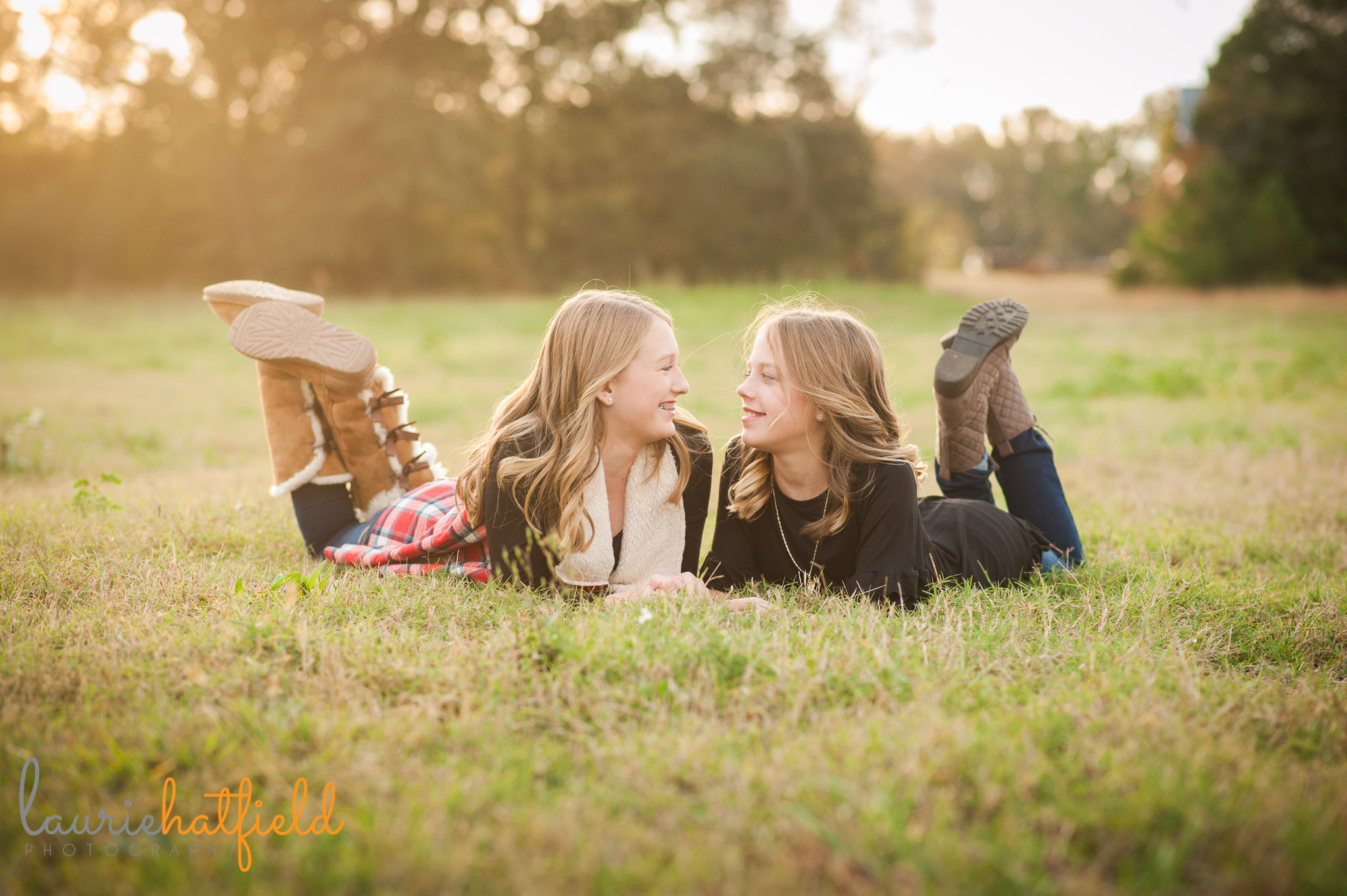 sisters lying down in a field | Mobile family photographer