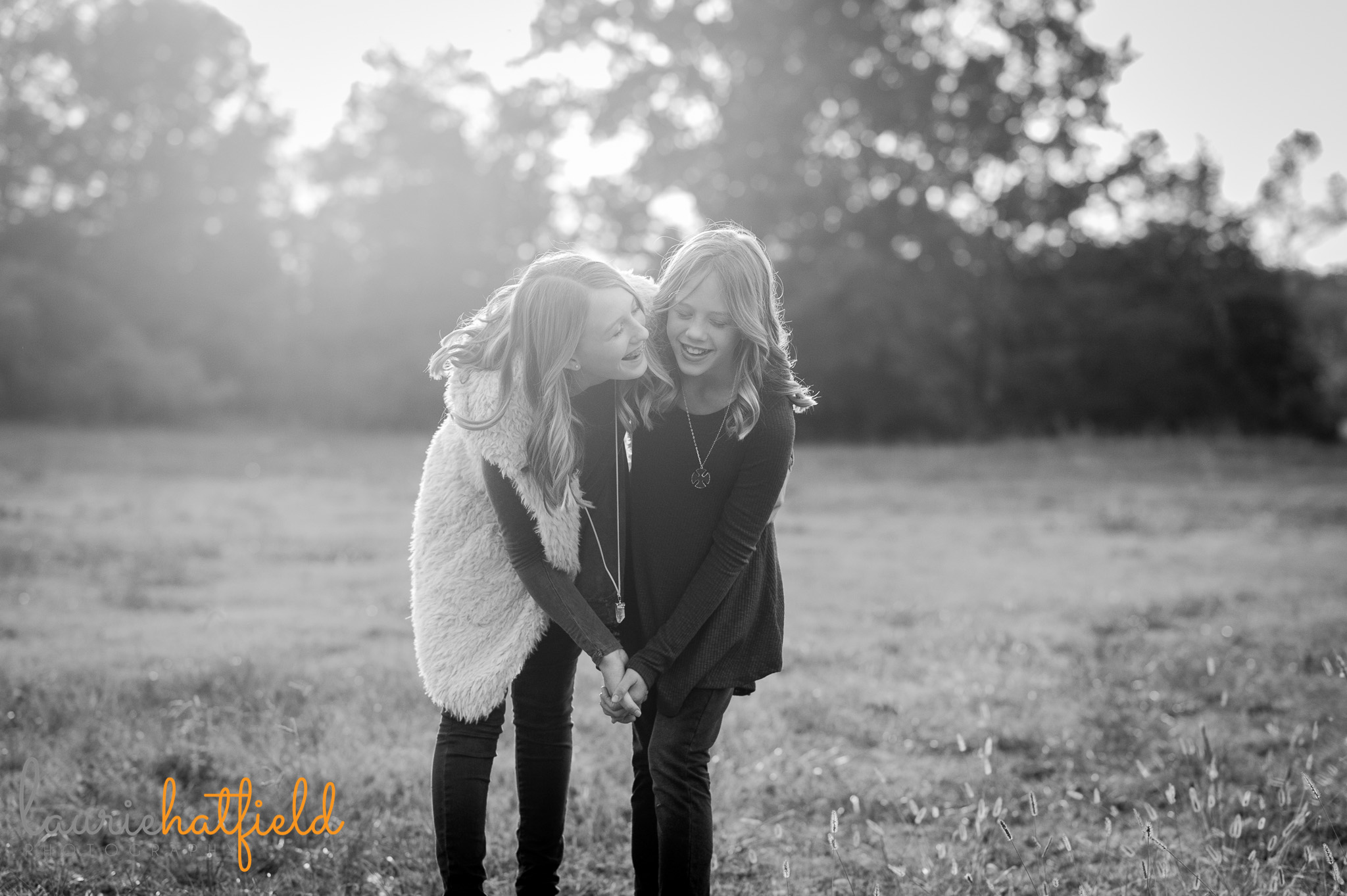 sisters laughing in a field | Mobile family photographer