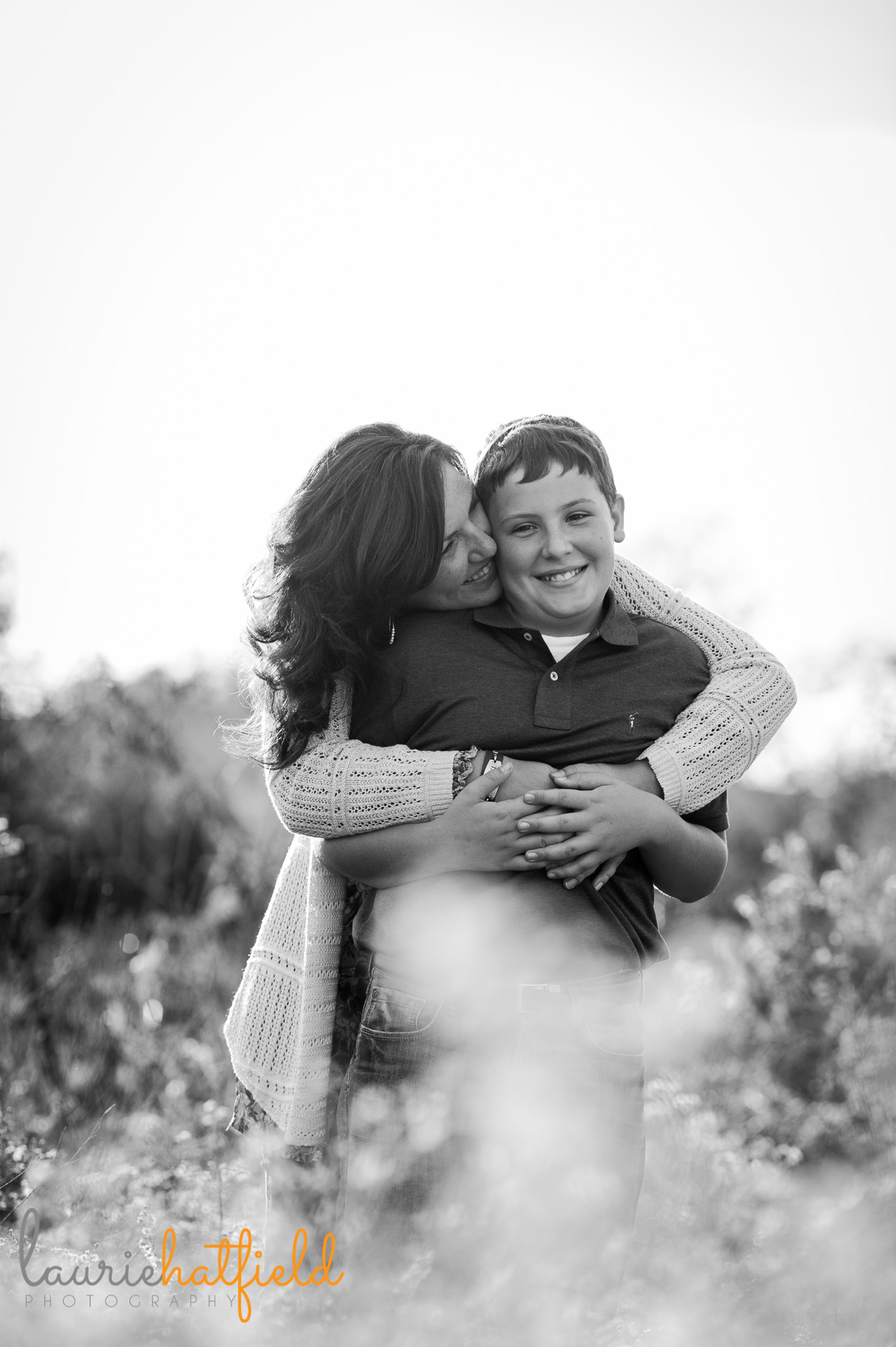 mom hugging son in field | Mobile family photographer