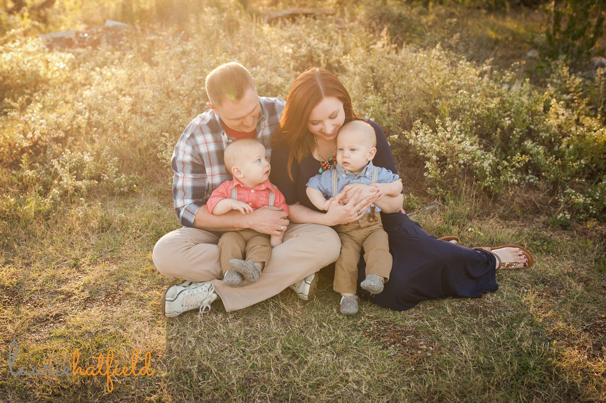 family with twin babies sitting in grass