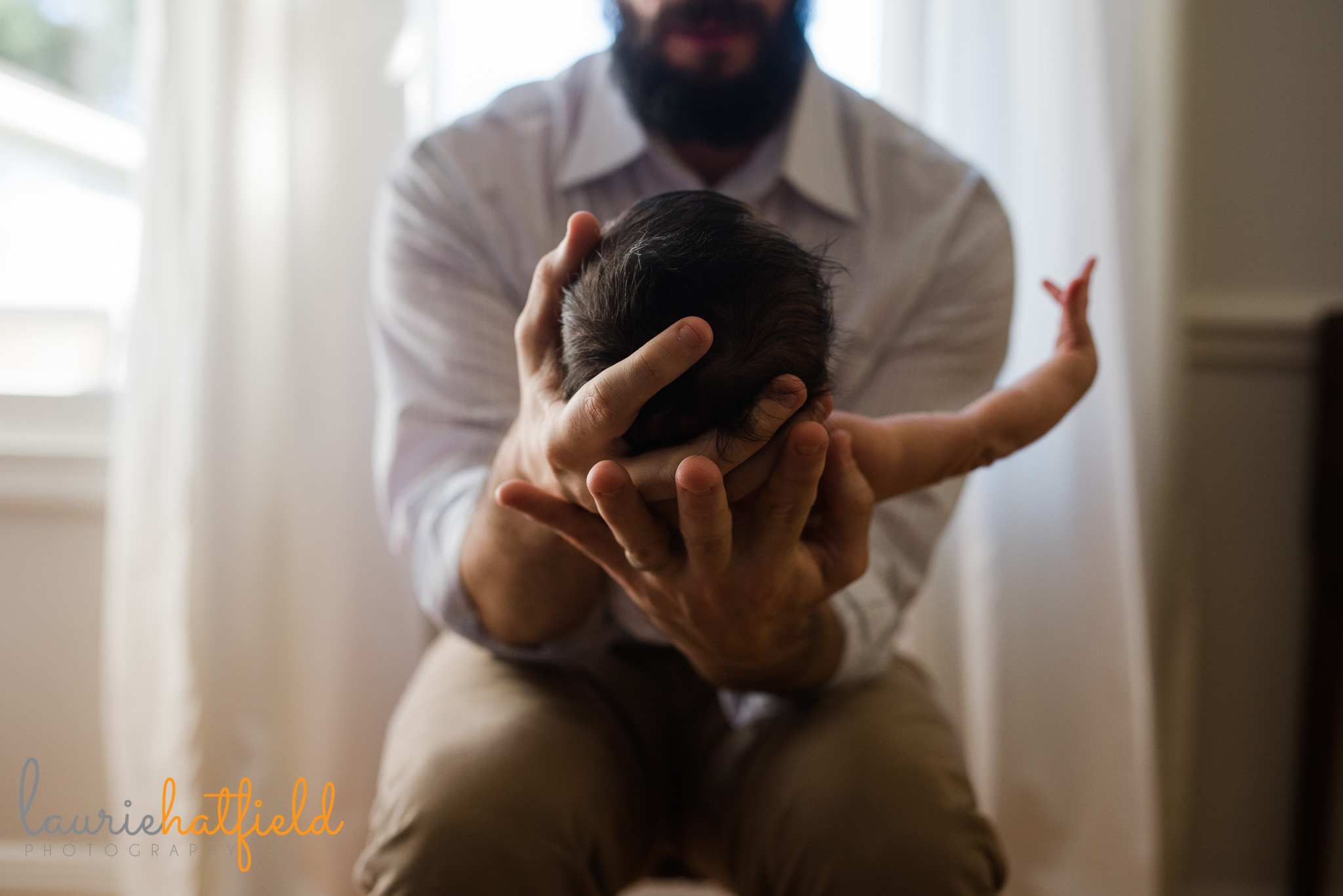 dad holding baby boy in hands | Mobile newborn photographer