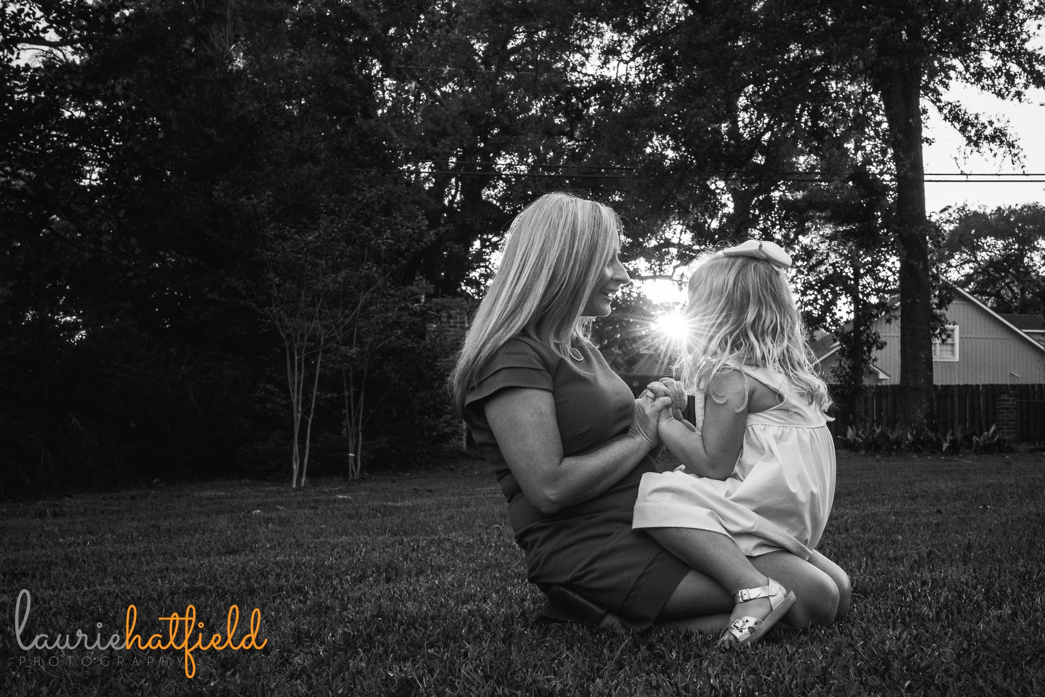 mom sitting with little girl on grass by Mobile AL family photographer Laurie Hatfield Photography