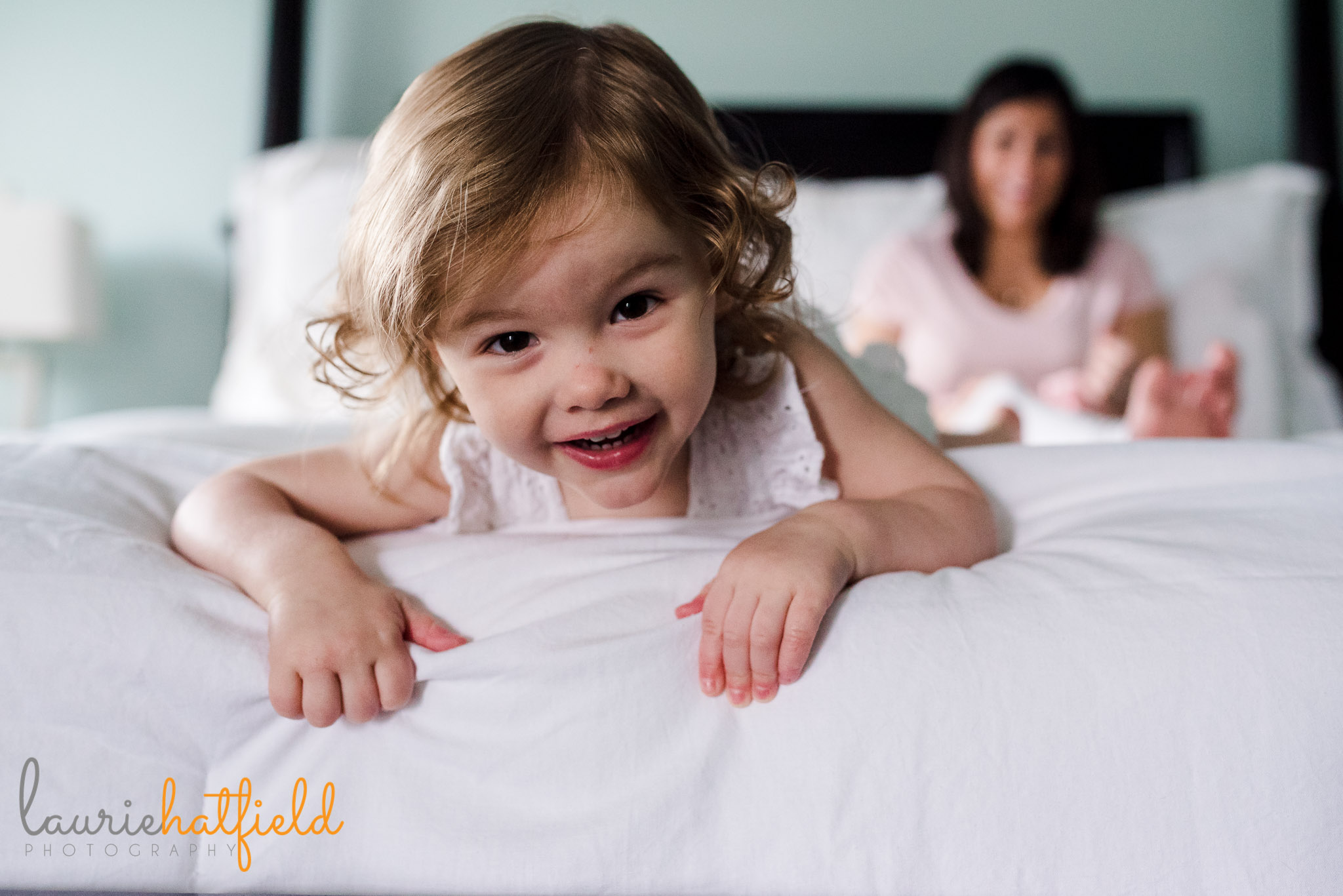 2-year-old girl playing on bed | Mobile AL newborn photographer