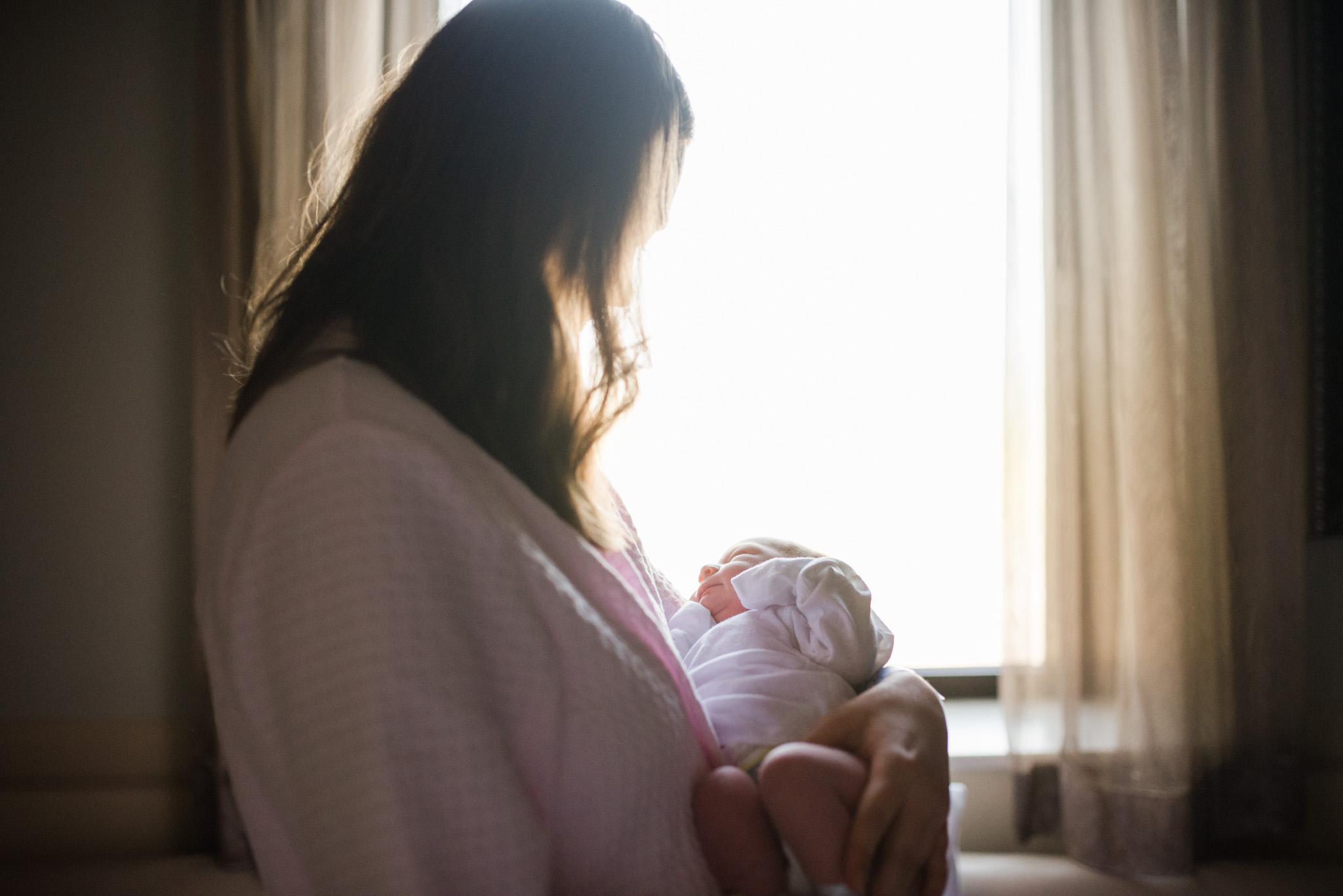 mom holding baby girl in hospital after birth | Mobile AL newborn photographer