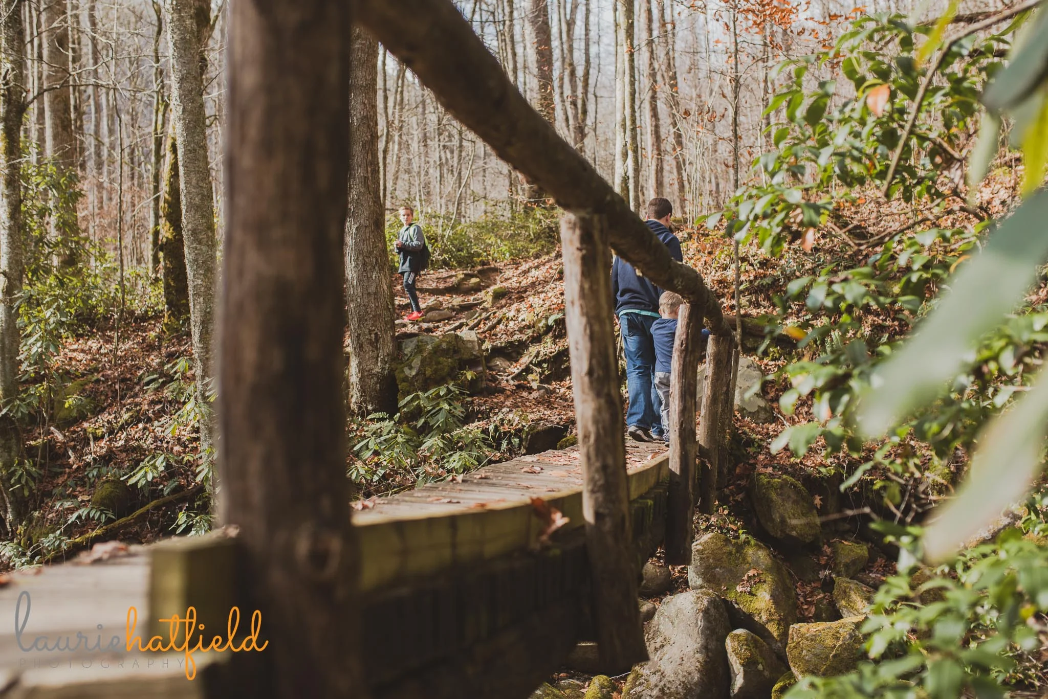 family hiking across a bridge | Mobile AL photographer