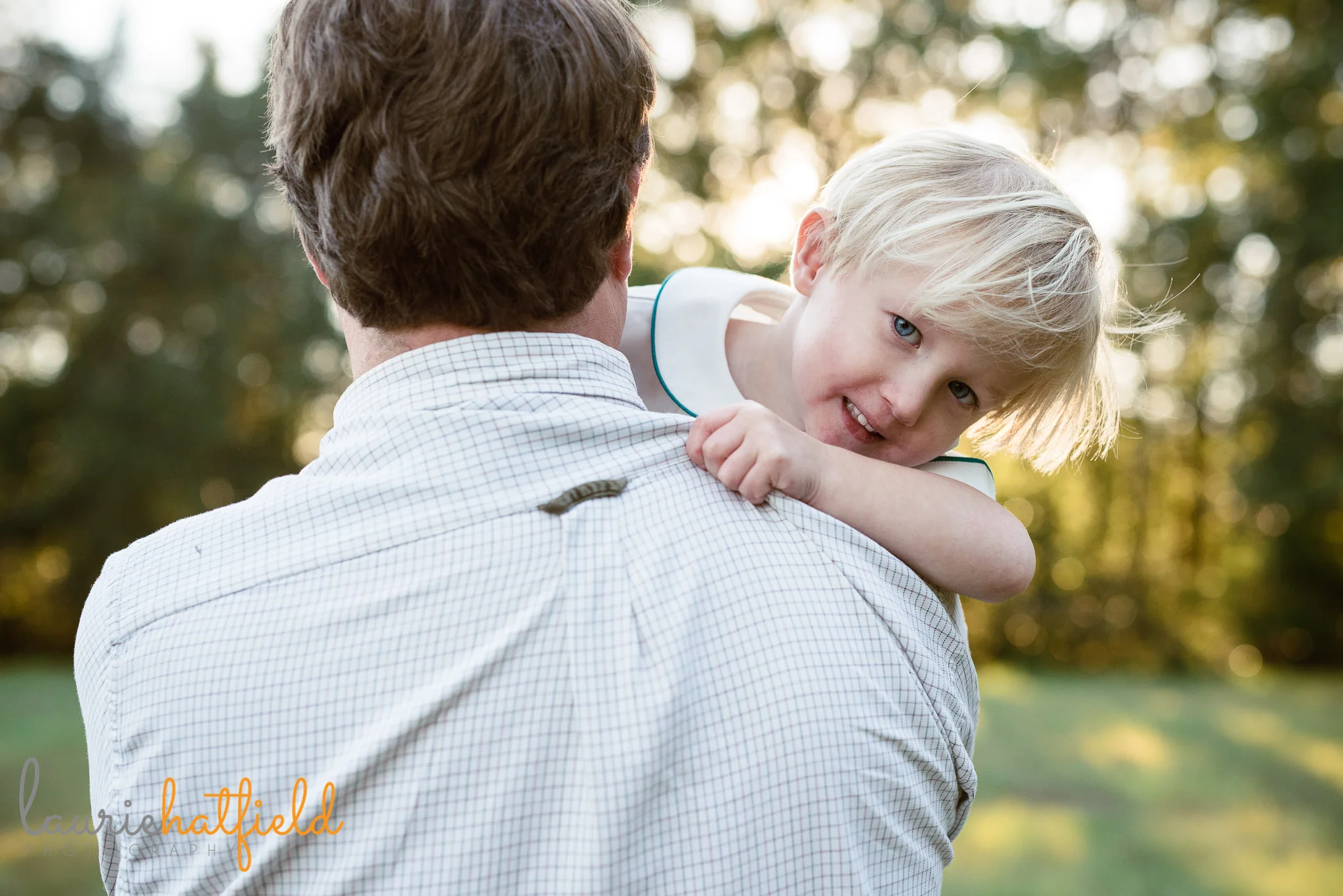 little boy peeking over dad's shoulder | Fairhope AL family photographer