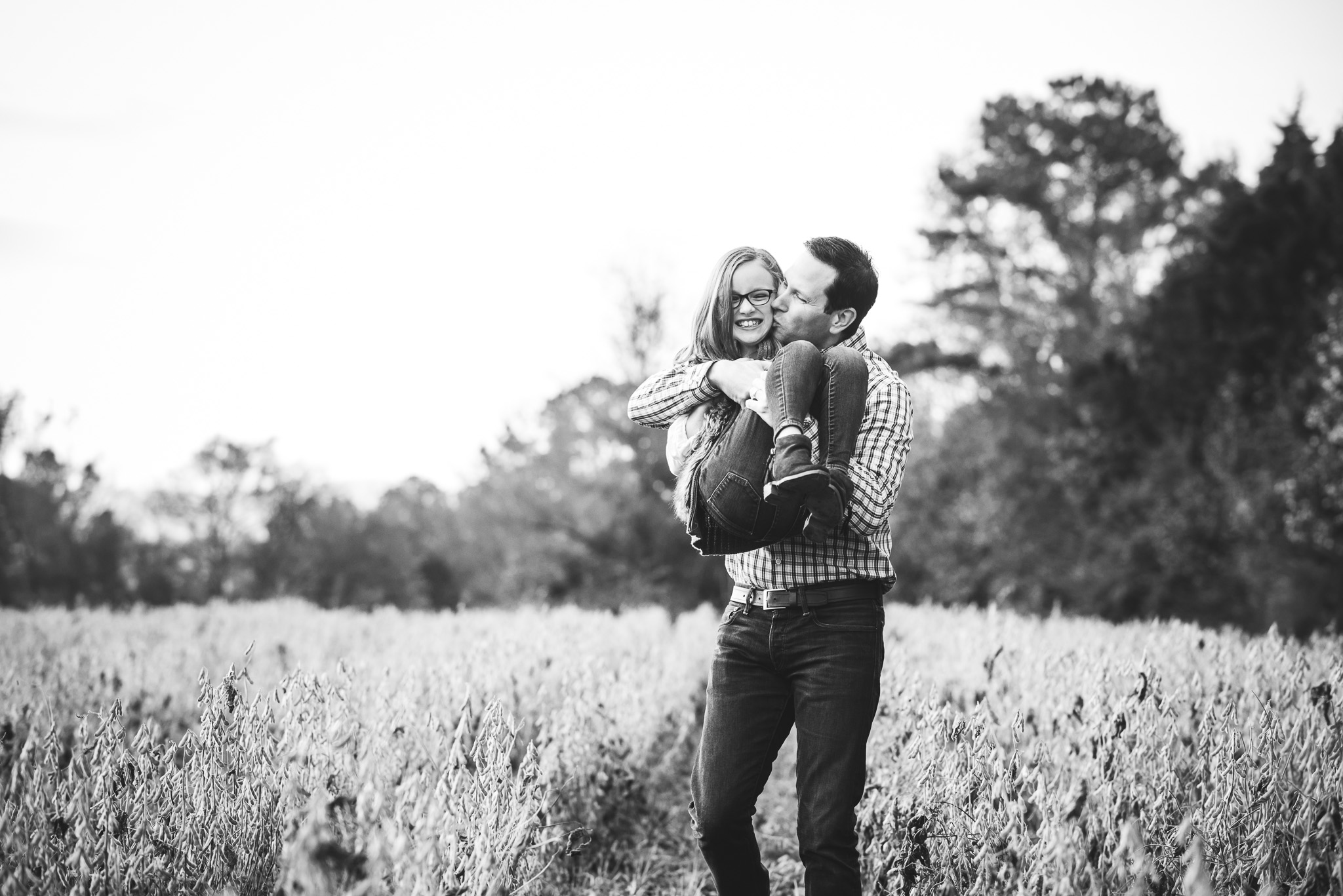 dad holding 8-year-old daughter in field | Mobile AL family photographer