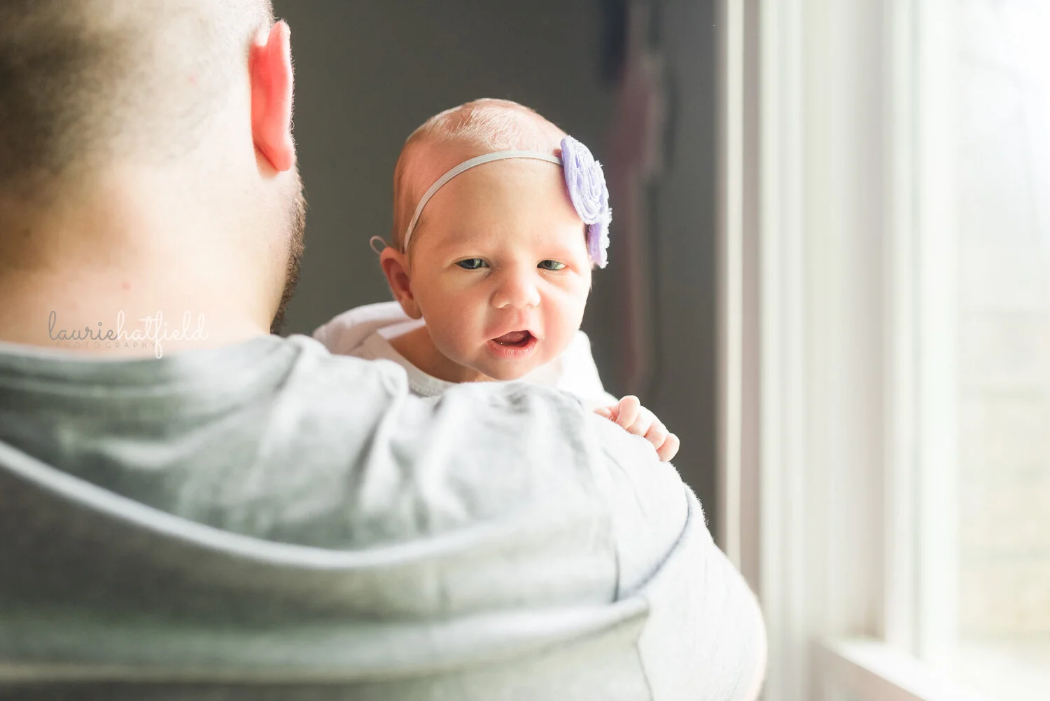 baby girl peeking over dad’s shoulder | Huntsville Al newborn photographer