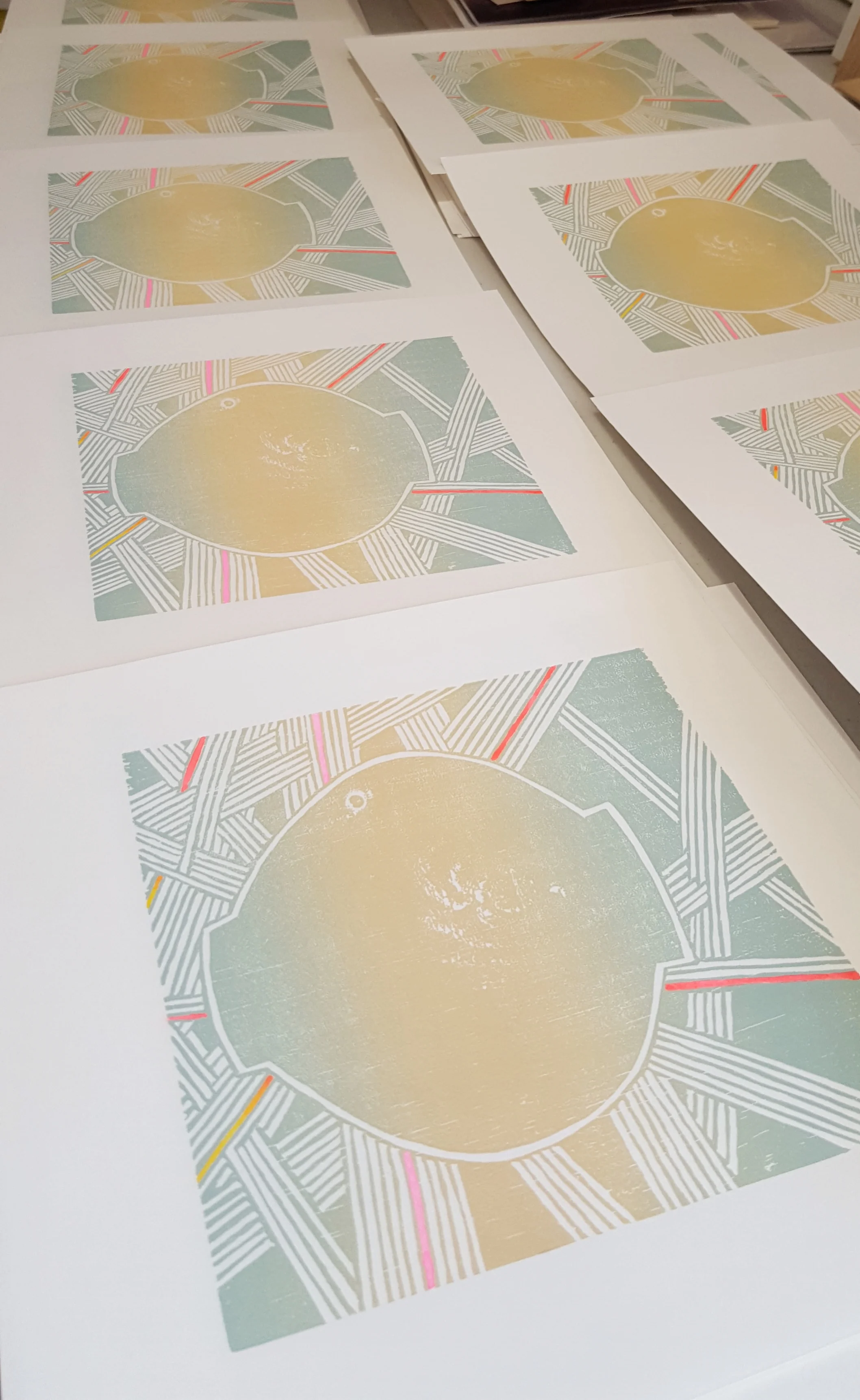 prints drying after being hand-painted with gouache.