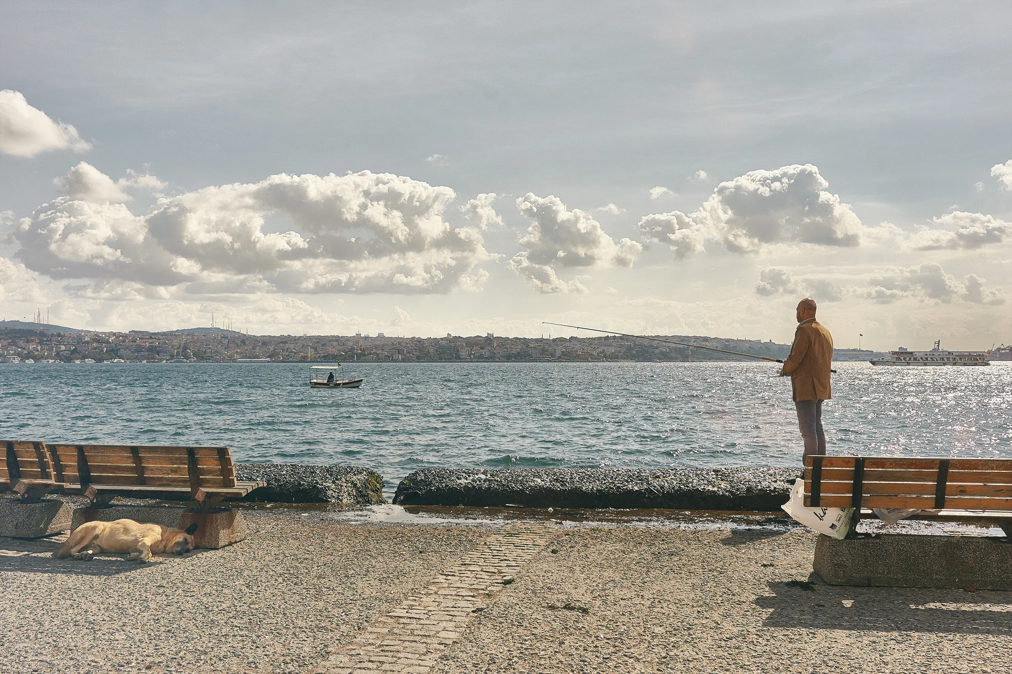 Some life, huh? A man fishing by the Bosphorus on a Tuesday lazy morning. His dog must love it. Istanbul.