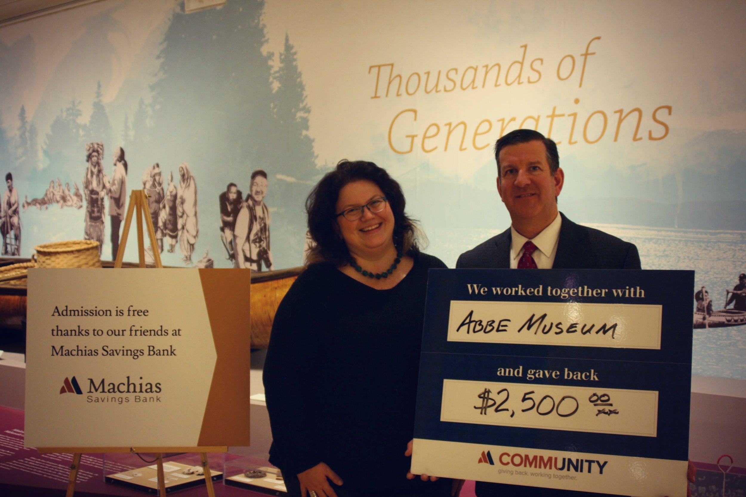 Machias Savings Bank Branch Manager Matt Horton presents Abbe Museum President and CEO Cinnamon Catlin-Legutko with a check in support of the Abbe's free admission program