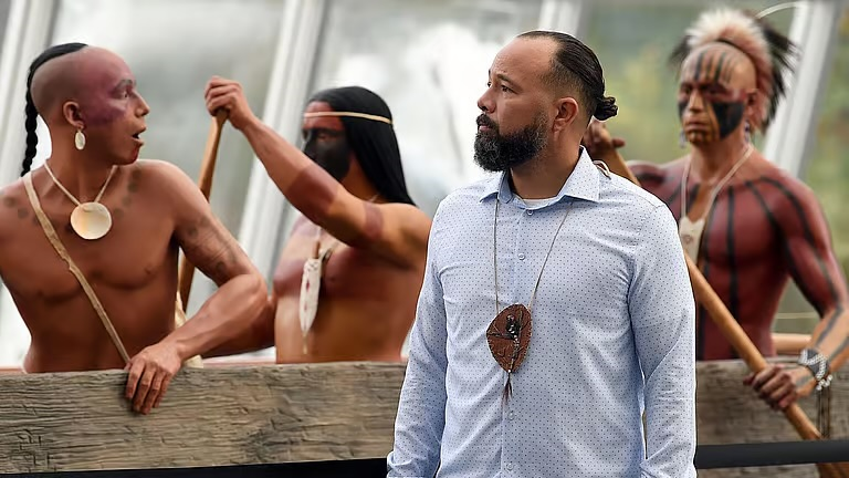 Joshua Carter - DFAI Market Artist - in front of canoe with three mannequins