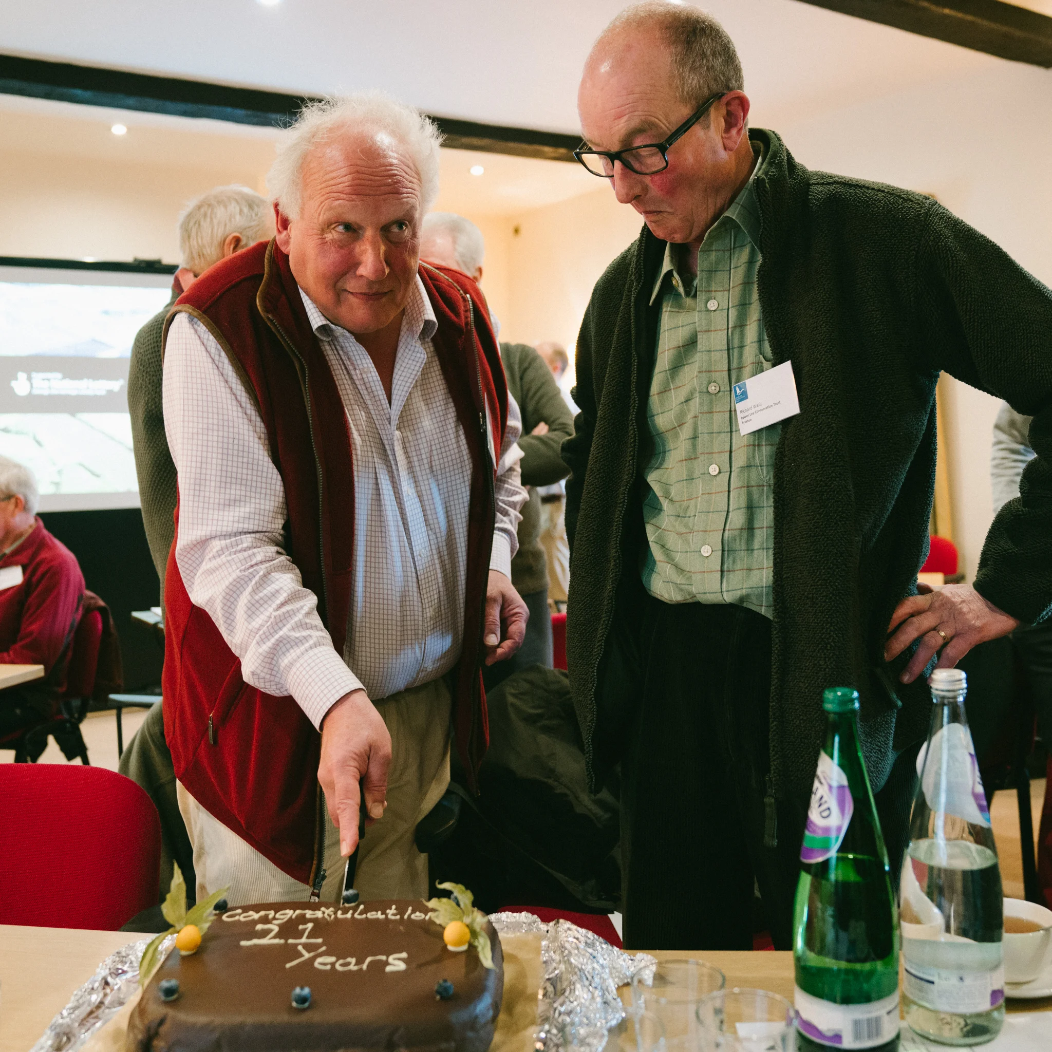 Trustees Simon and Richard cutting the birthday cake