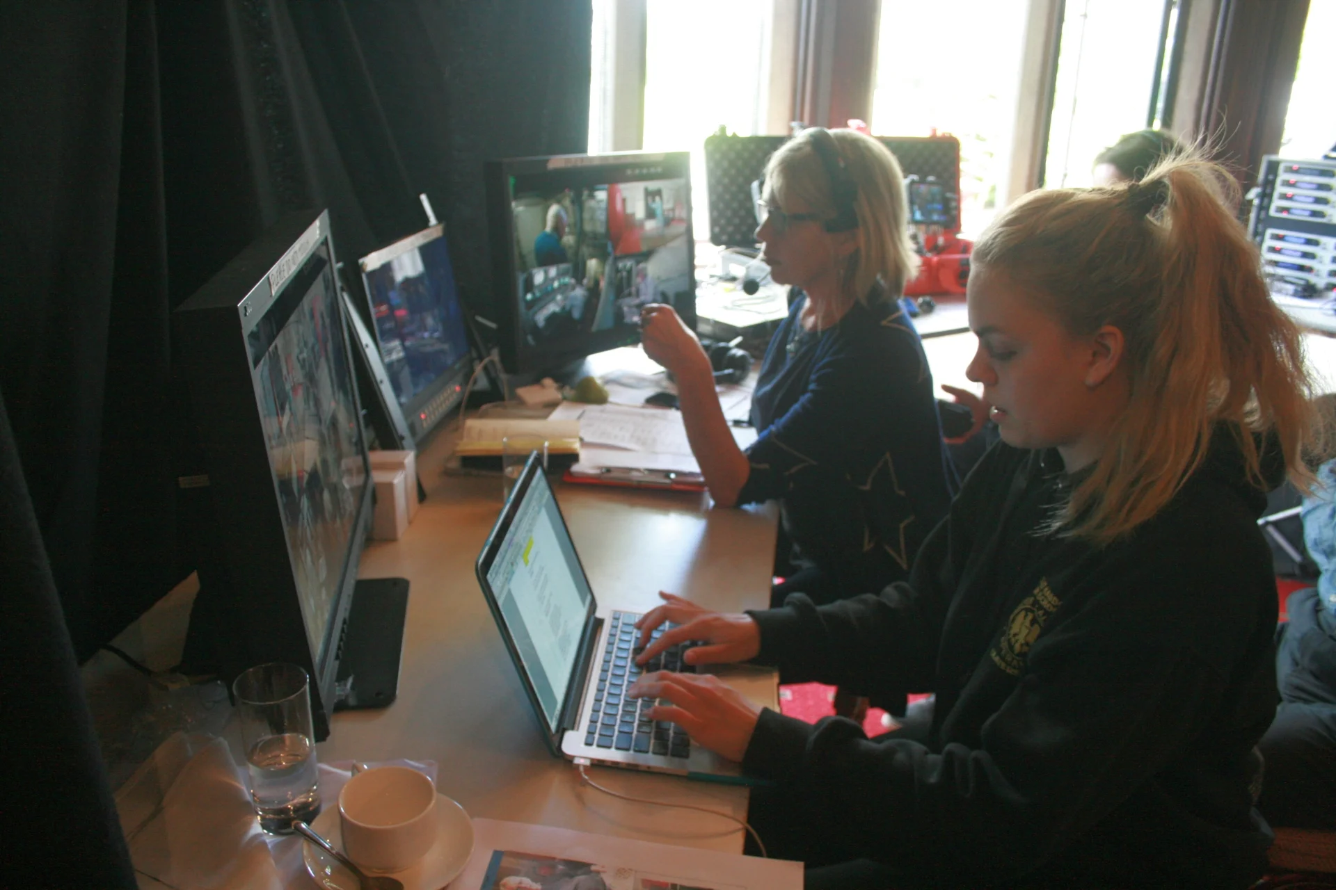 In a makeshift production gallery, producer Amanda Murphy watches camera feeds of the historical re-enactment, while Royal Holloway media student Amy Clark (foreground) makes a detailed log of events.