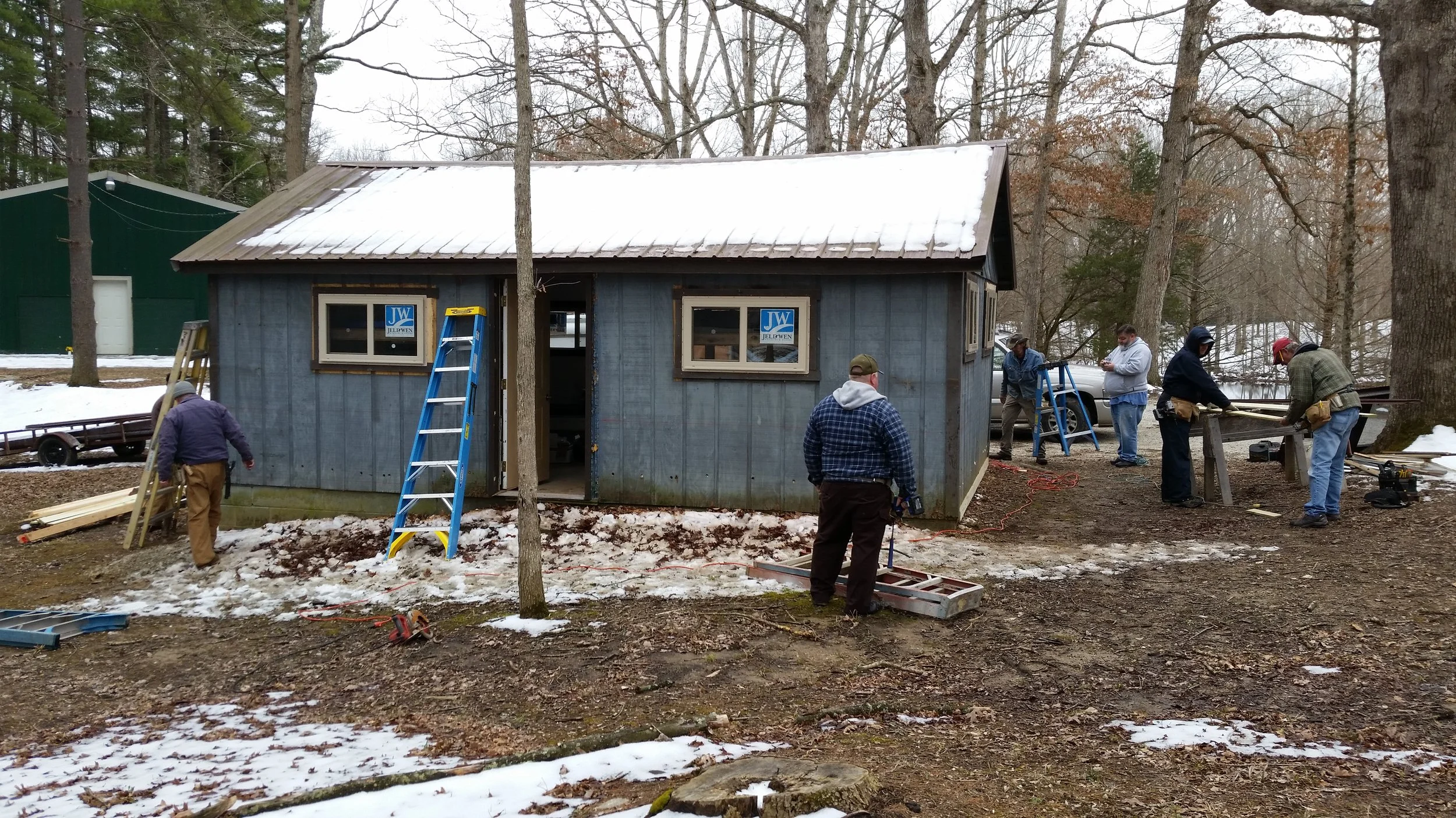 ABM of Long Run Association installing metal siding on their Cabin #17.
