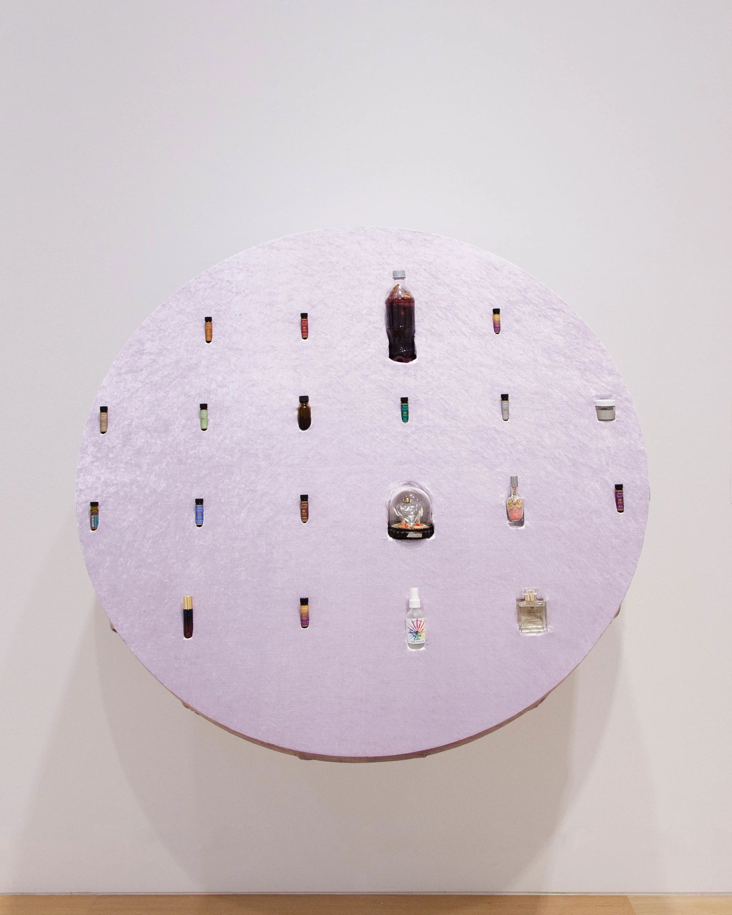 Matt Morris. Advanced Potions , 2019 Perfumes, family, potions, essences, spells, elixirs, chosen family, tinctures, anointing oils, casein paint medium, friendships, social networks, velvet, foam Display fabricated by Christopher Lee Hare Image courtesy of the DePaul Art Museum 1. Twelve anointing oils that Matt Morris’ father, Butch Morris, received as a gift six months before he died in June 2018. In the 1980s, Butch’s Baptist church split over disagreements about whether fragrant anointing oils used for prayer was doctrinally sound. He and his family joined a new church where the use of these oils was integral to religious practices. 2. Catalina Ouyang . death drive joy ride elixir assembled by Matt Morris based on a recipe that Ouyang's mother, Jie Li, inherited from her own parents. E jiao (donkey hide gelatin), Cabernet Savignon, rock sugar, chrysanthemum, hibiscus, noble dendrobium flowers, hawthorn berries, cordyceps mushrooms, white fungus, ginseng, ginger, dried jujubes, shan zha pian (hawthorn candies), rosemary, lychee jelly 3. Michael J. Morris . Love spell, 2018. Patchouli, almond, musk, vanilla, cinnamon. Formula based on spell in Phyllis Curott’s The Love Spell: An Erotic Memoir of Spiritual Awakening . New York: Gotham Books, 2005. 4. Josh Dihle . Casein paint medium, hand-mixed March 2019 Cottage cheese, water, ammonia 5. Babs Forever Yours perfume bottle, ca. 1930s, New York 6. Rhonda Wheatley . Cure Bottle for self-misconception. Brings one’s consciousness into soul-level awareness of the self , 2019 Found perfume bottle, pink sand, pink Himalayan salt, lavender, helichrysum flowers, calendula flowers, moss, other dried flower petals. 7. Kiam Marcelo Junio / Mahal Healing Arts . Personalized aromatherapy blend gifted to the artist, December 2018 Camellia Seed (Camellia oleifera), Jojoba (Simmondsia chinensis), Baobab (Adansonia digitata), Grapefruit (Citrus paradisi), French Lavender (Lavendula angustifolia officinalis), Co-distilled Neroli and Petitgrain (Citrus aurantium var. amara), Frankincense (Boswellia serrata), Cypress (Cupressus sempervirens), Australian Sandalwood (Santalum spicatum), Immortelle (Helichrysum italicum), Atlas Cedarwood (Cedrus atlantica), Rosemary (Rosmarinus officinalis), Gardenia-Agarwood Attar (Gardenia jasminoides, Aquilaria malaccensis), pyrite, amethyst. 8. Dori Midnight . Boundaries in a Bottle . Witchcrafted with essences of yarrow, spider full moon, rosemary, echinacea, cedar, black tourmaline, citrine, smoky quartz, snowflake, obsidian, stone circle and salt. Essential oils of pine and cedar. Provides radiant protection, clearing, and grounding. Dori Midnight practices community-based intuitive healing that weaves plant and stone medicine, ancestral and queer magic, and justice work. 9. Liz Moores. Angelique , Eau de Parfum for Papillon Artisan Perfumes , 2014 Fragrance notes: Iris Pallida, Osmanthus, French mimosa, White champac, Orris, Virginian cedarwood, Frankincense The window in Matt Morris’ childhood bedroom in Baton Rouge, Louisiana opened onto a flowerbed that contained an abundance of irises and an osmanthus tree his mother planted (also known as the sweet olive tree).