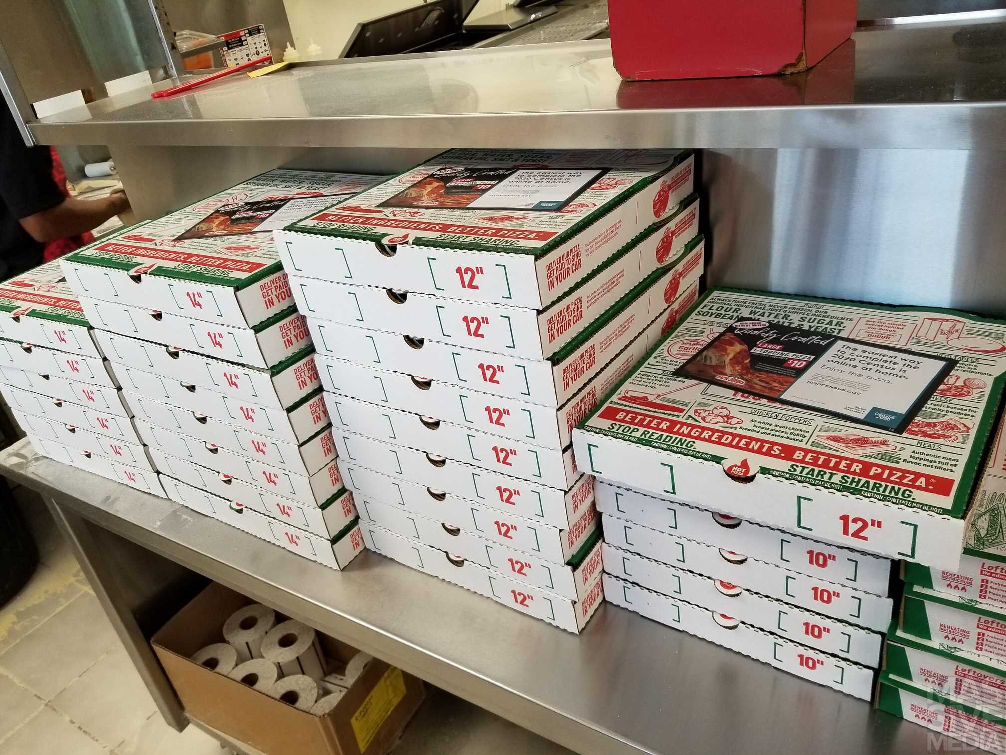pizza boxes with ads ready to be delivered