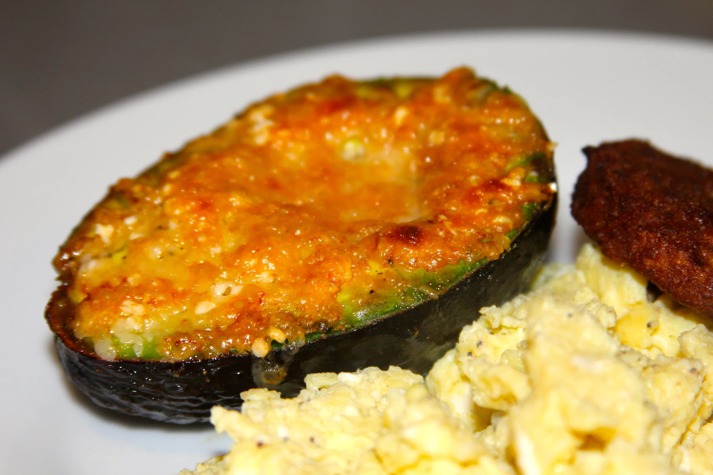 broiled avocado with parmesan cheese & sriracha sauce