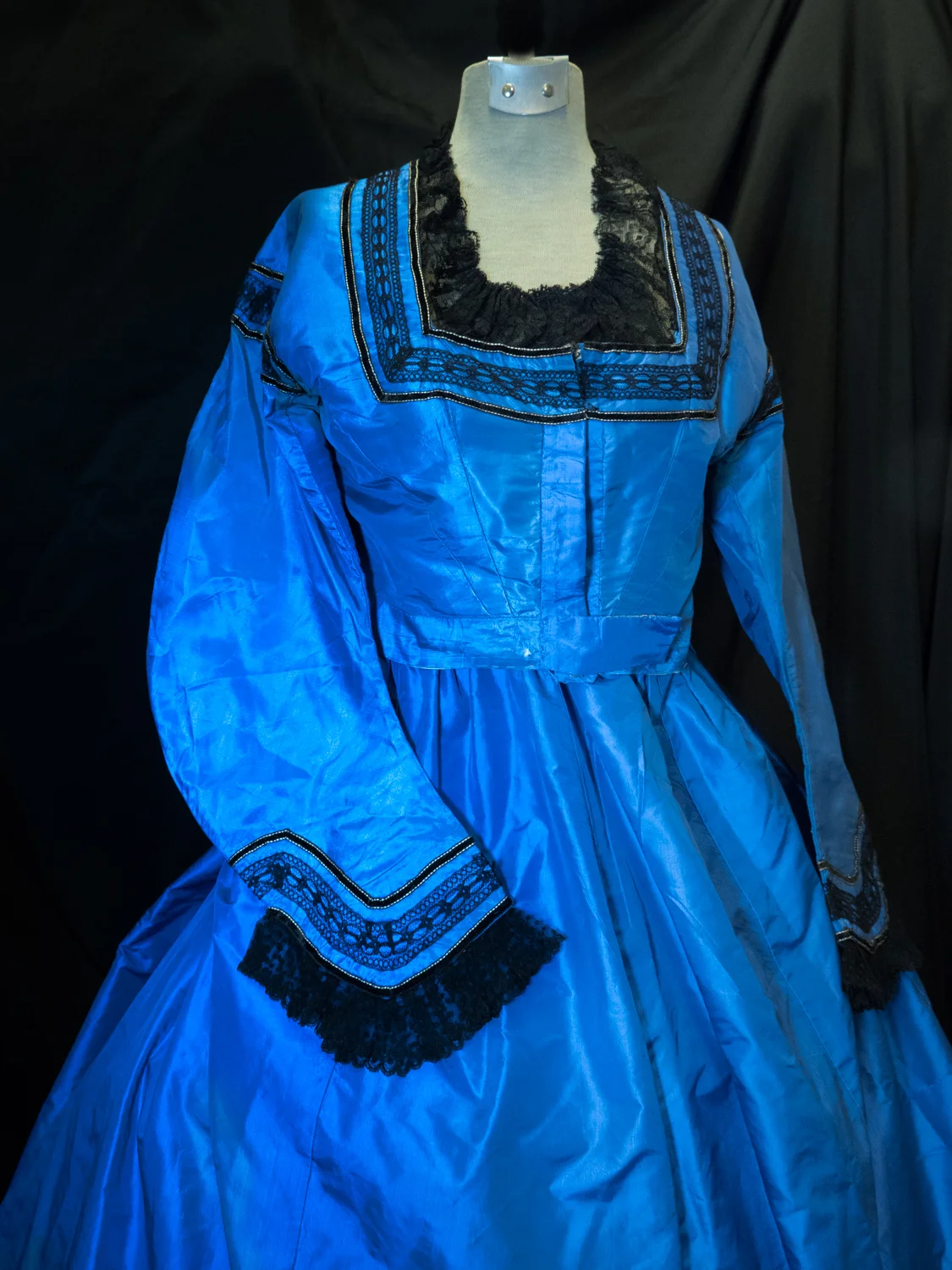 Dinner dress circa 1863. Silk taffeta aniline. Blue trimmed with black laces and black velvet ribbon skirt. 