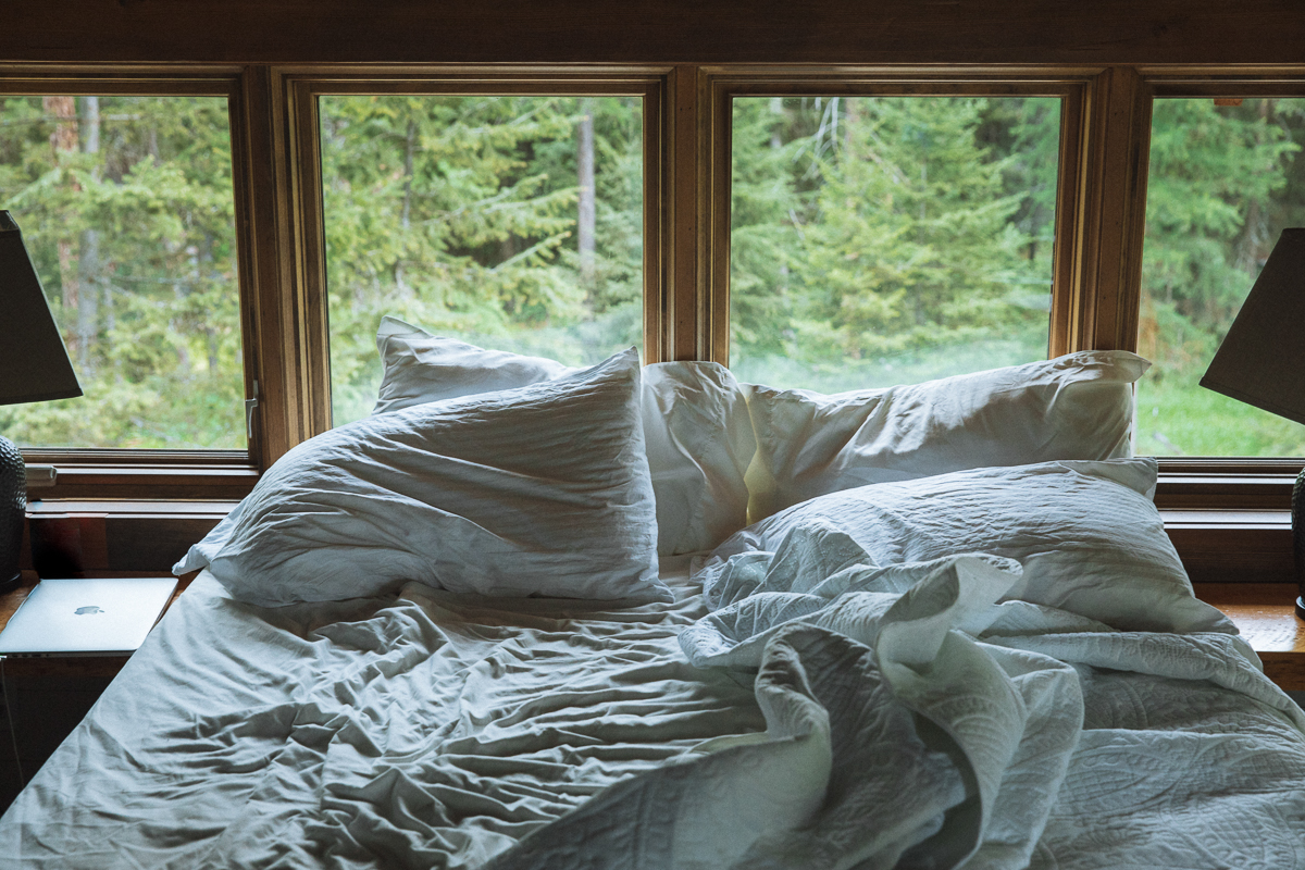 The master suite loft looks out over the forest with windows leading out to views of pine trees and seclusion. 