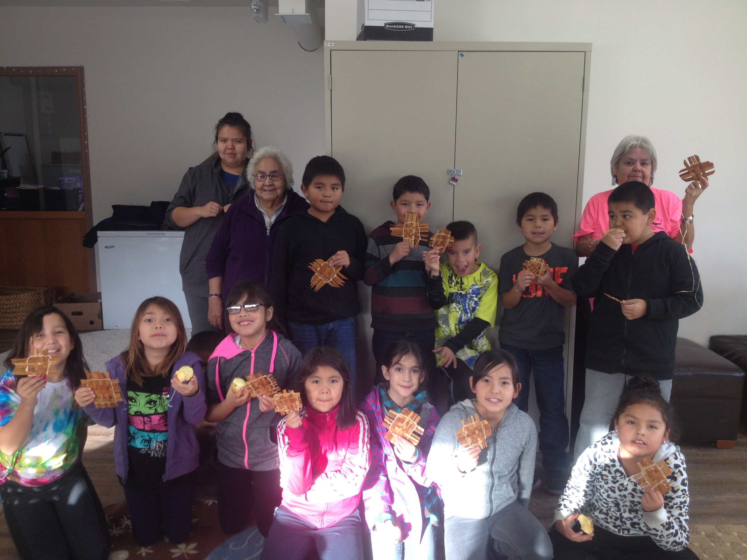 Students show off their woven cedar mats.