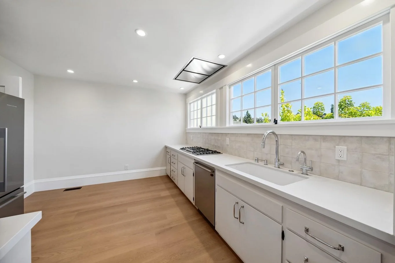 A fresh take on a familiar layout ✨ This kitchen kept its original footprint but got a major upgrade in style and function. We brightened the space with lighter cabinets, modern hardware, improved lighting, and new grid-style windows that add a timel